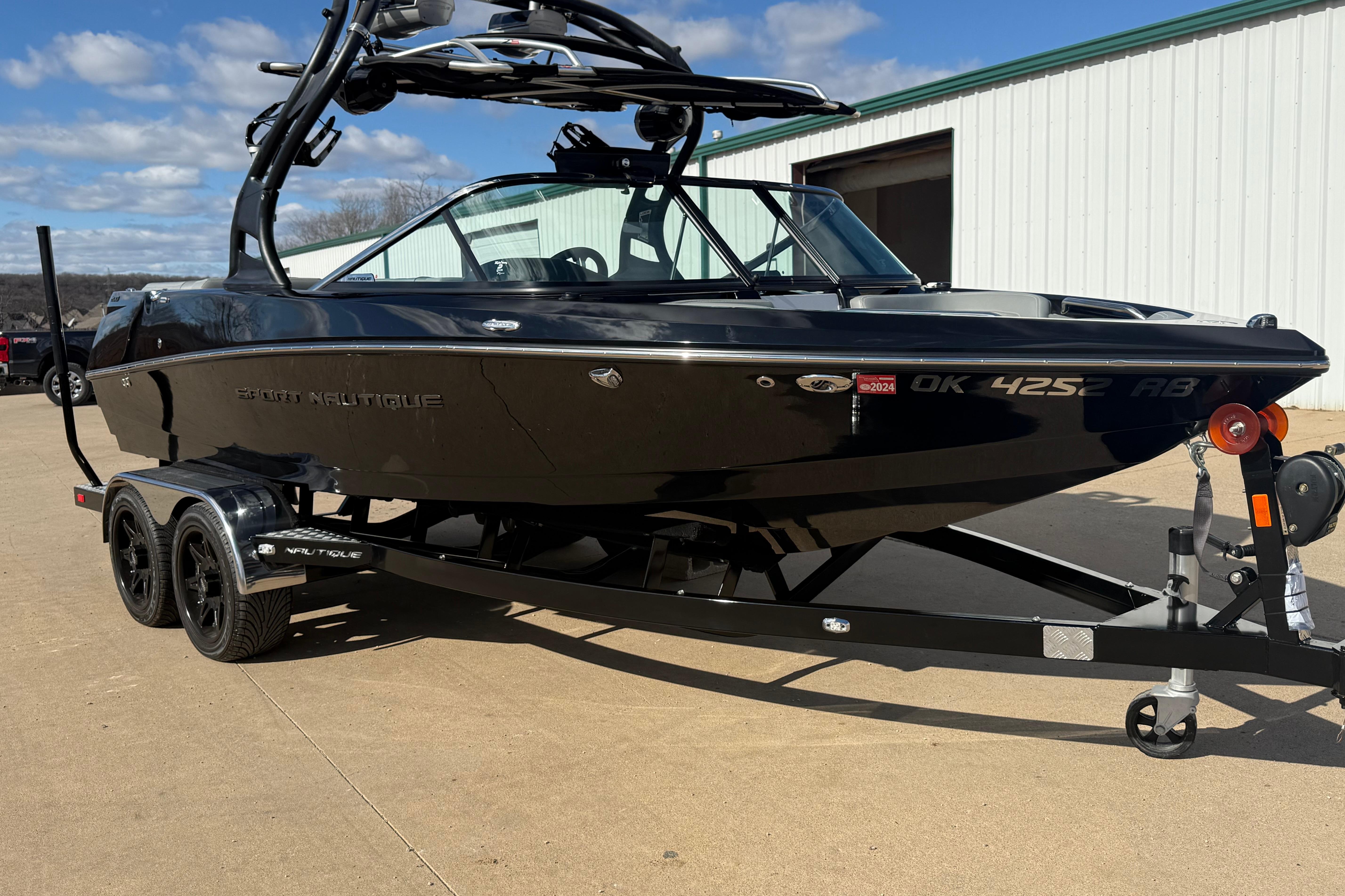 2014 Nautique Sport Nautique 200 boat on trailer, parked outdoors.