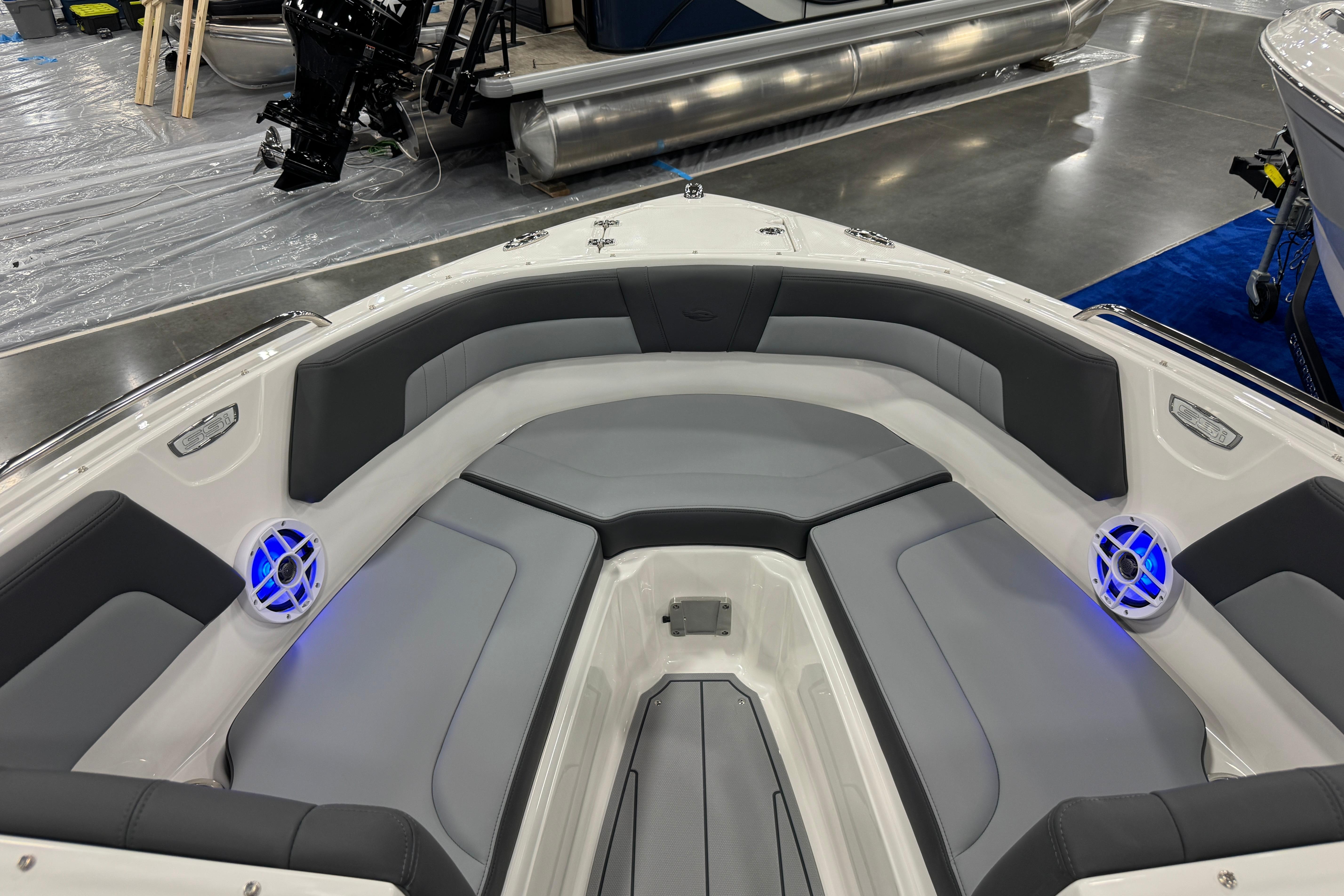 2026 Chaparral 23 SSi boat interior with gray seating and blue-lit speakers.