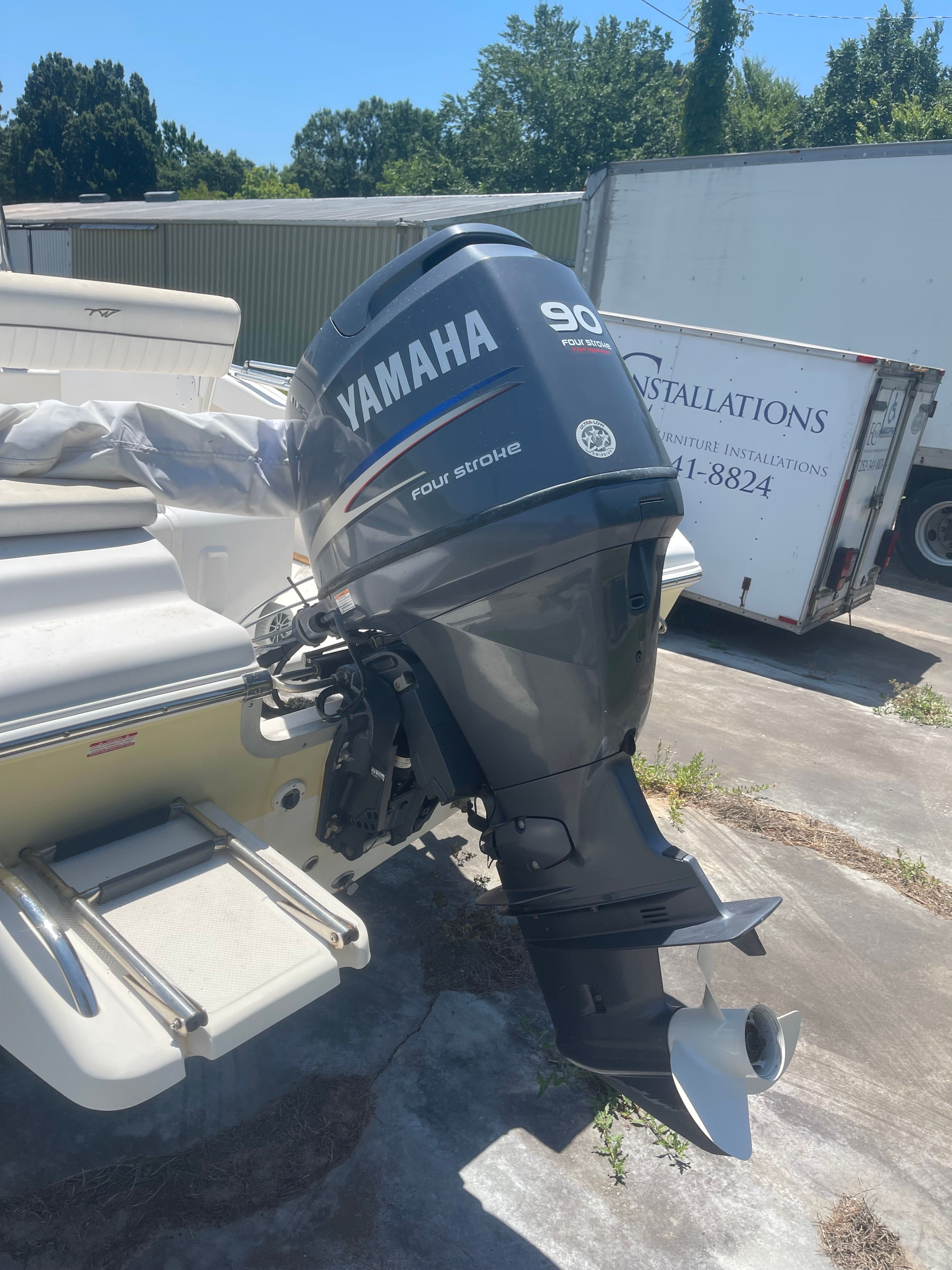 A boat with a Yamaha 90 HP outboard motor is on a trailer.
