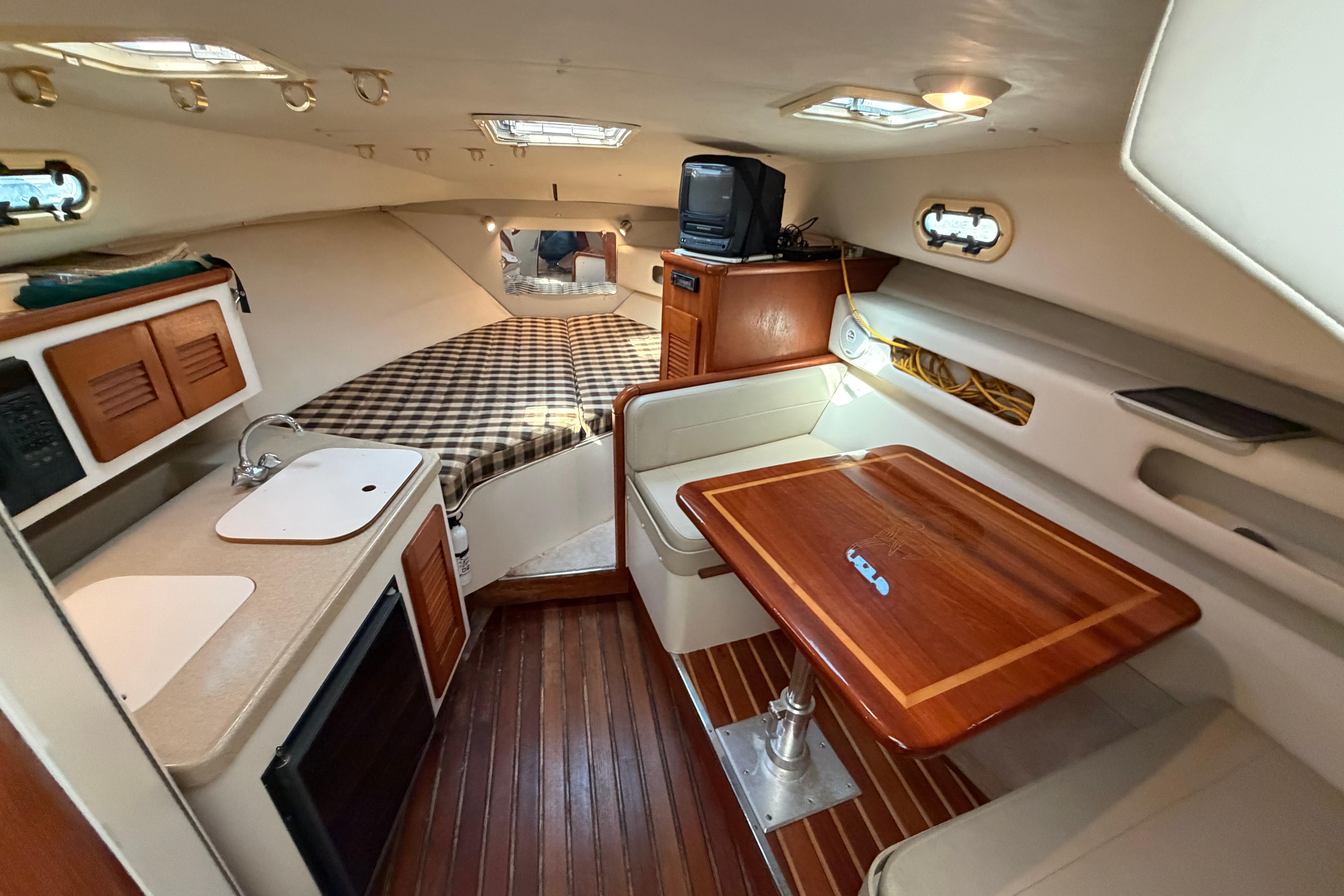 2001 Pursuit 3000 Express cabin interior with kitchenette, bed, and dining area.