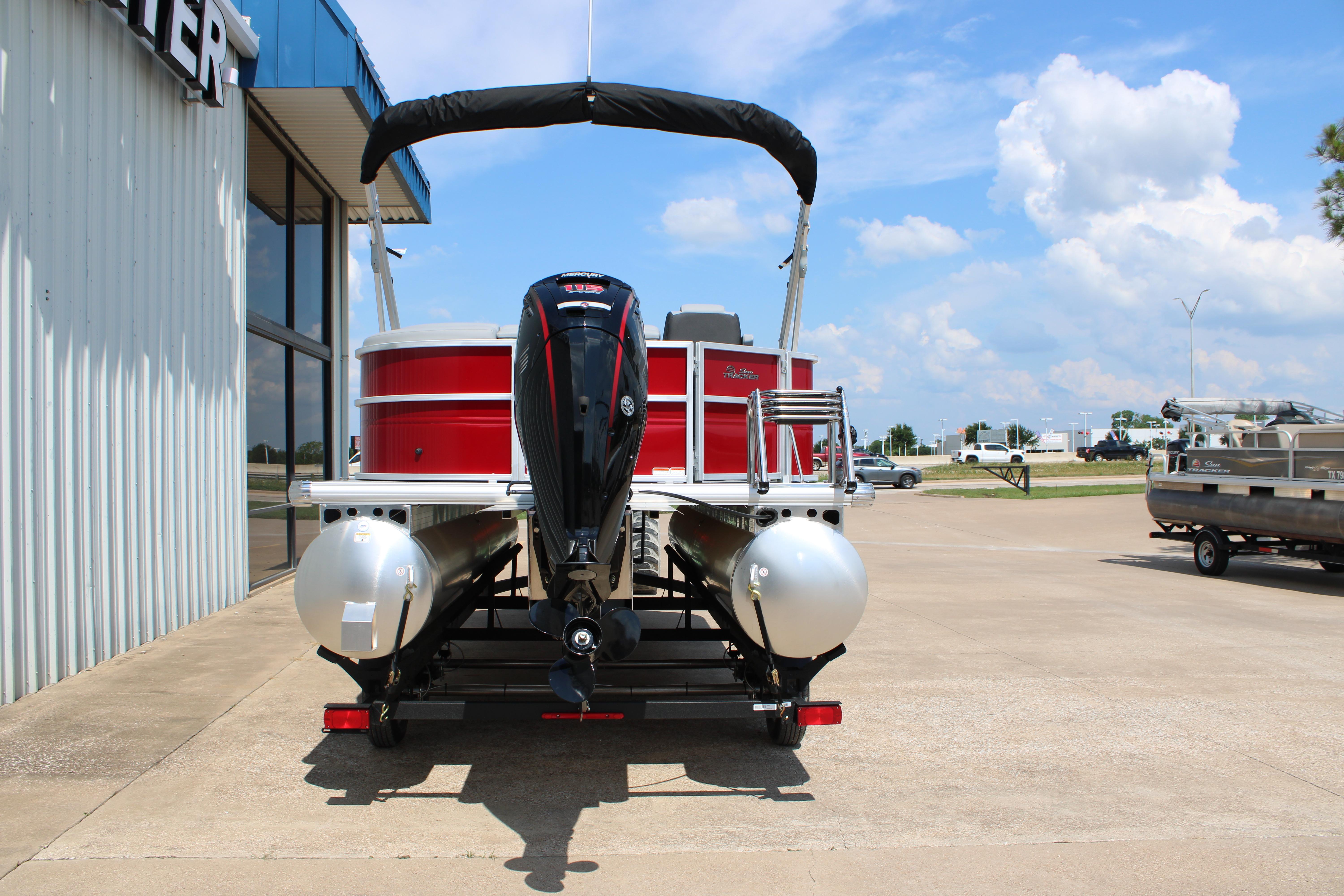 2026 Sun Tracker Party Barge 20 DLX pontoon boat with outboard motor, parked outdoors.