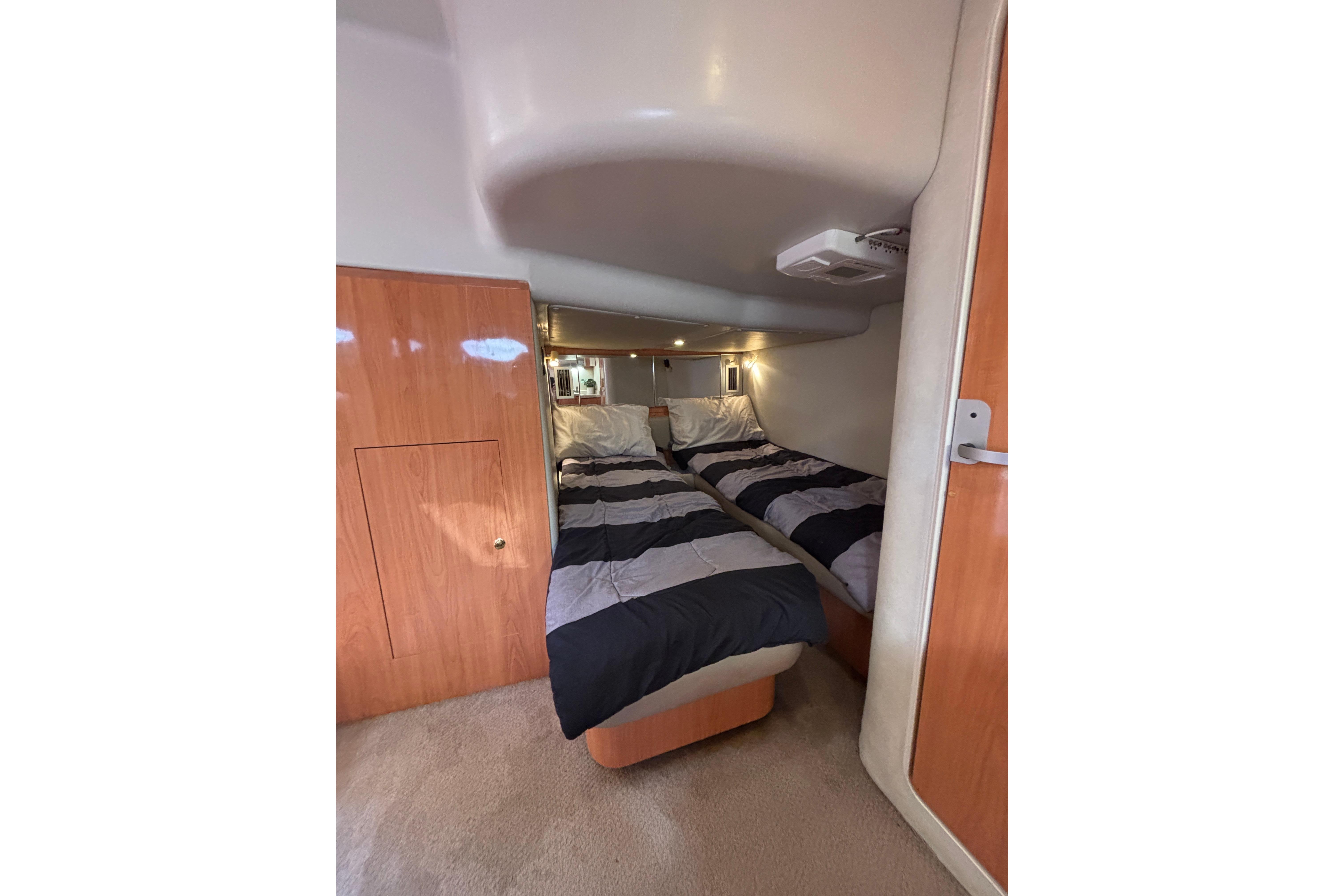 Interior cabin of 2000 Regal Commodore 4160 with twin beds and wood paneling.