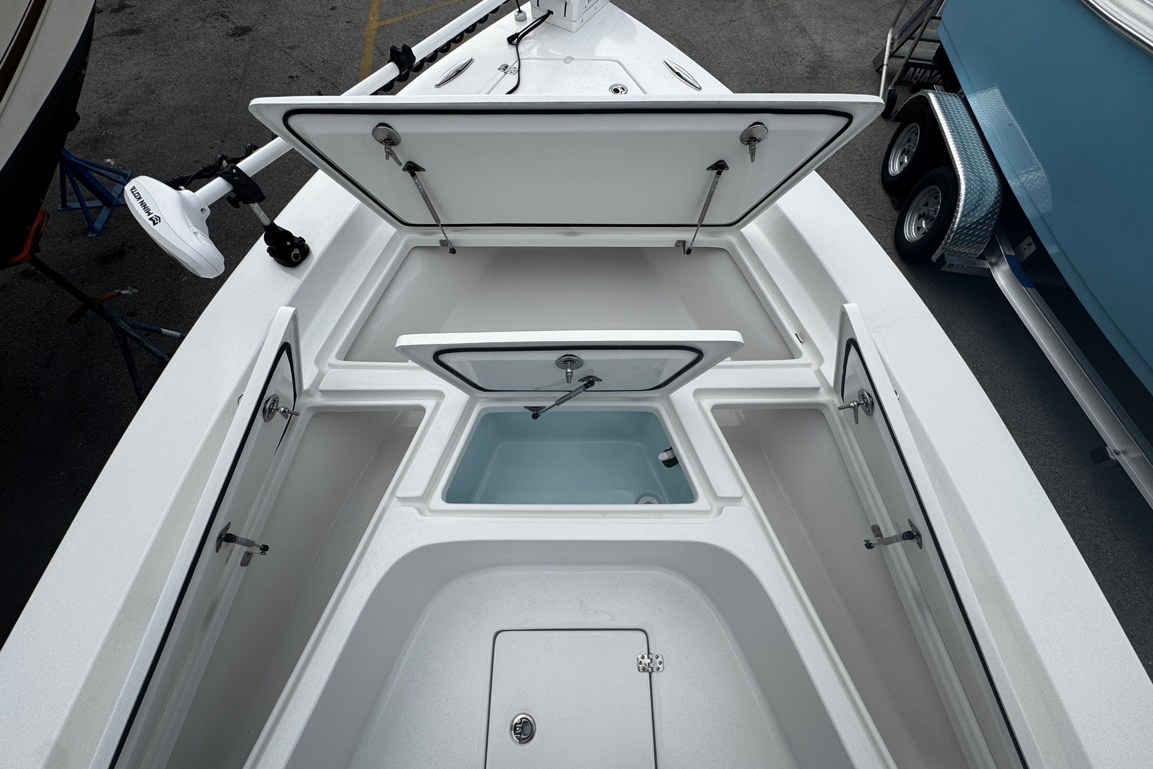 Open storage compartments on a 2026 Piranha Casador B2200 boat deck.
