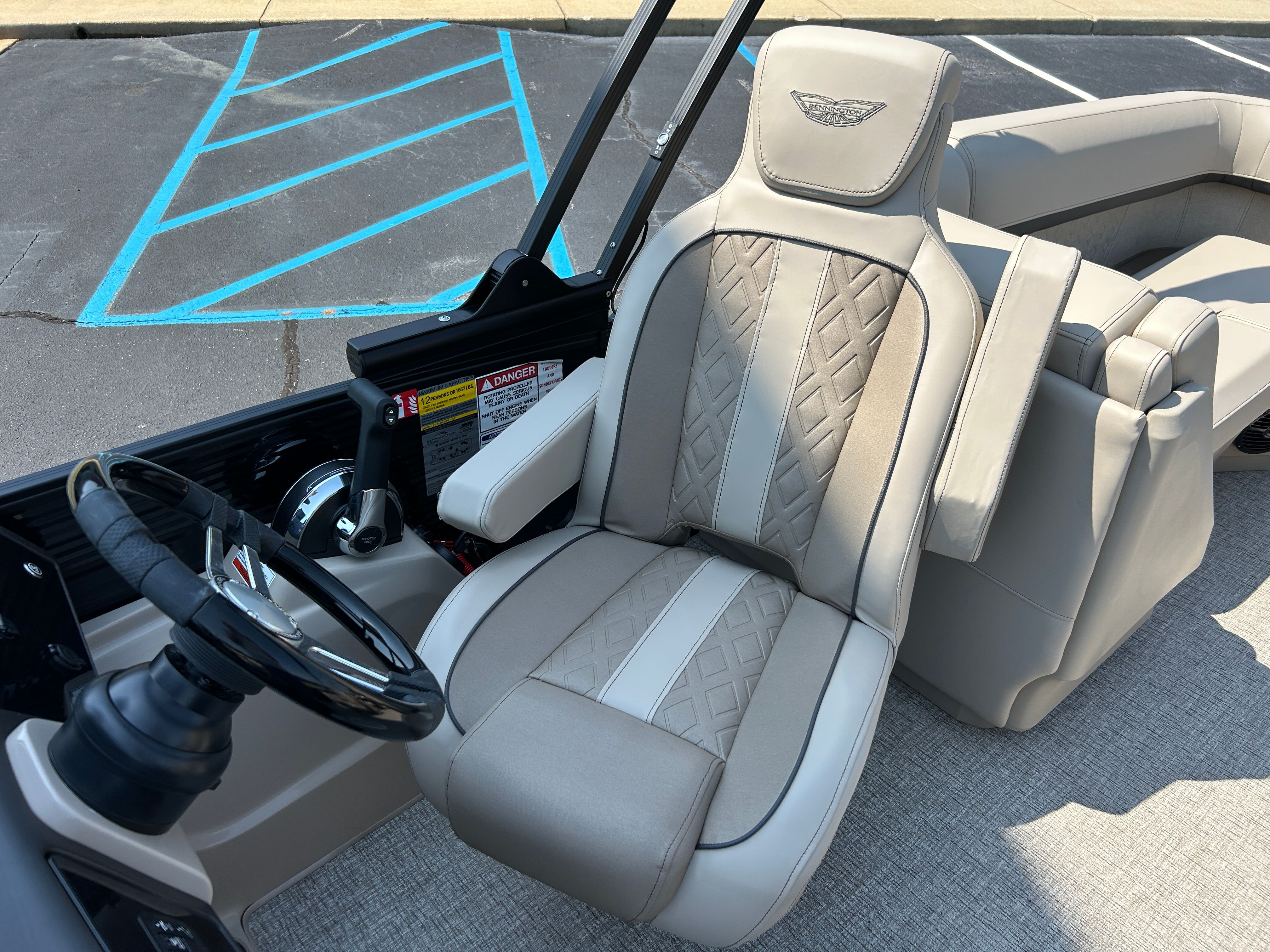 The image shows the driver's seat of a 2026 Bennington 22 MFB with elegant upholstery.
