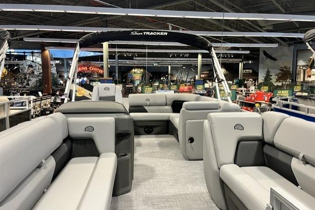 2026 Sun Tracker Party Barge 20 DLX pontoon boat with spacious seating in showroom.