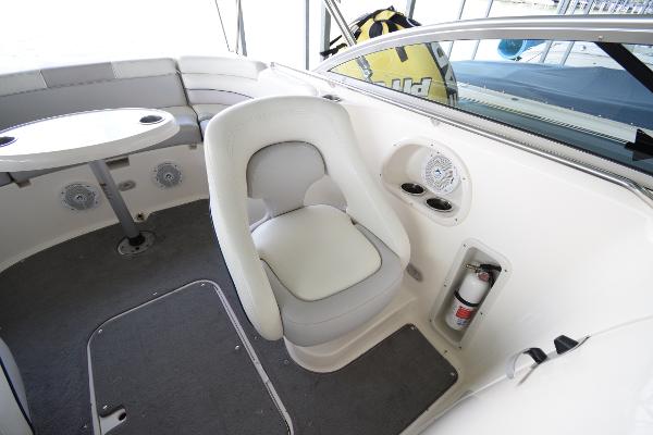 Interior of a Bryant 255 boat with a white seat and a table.