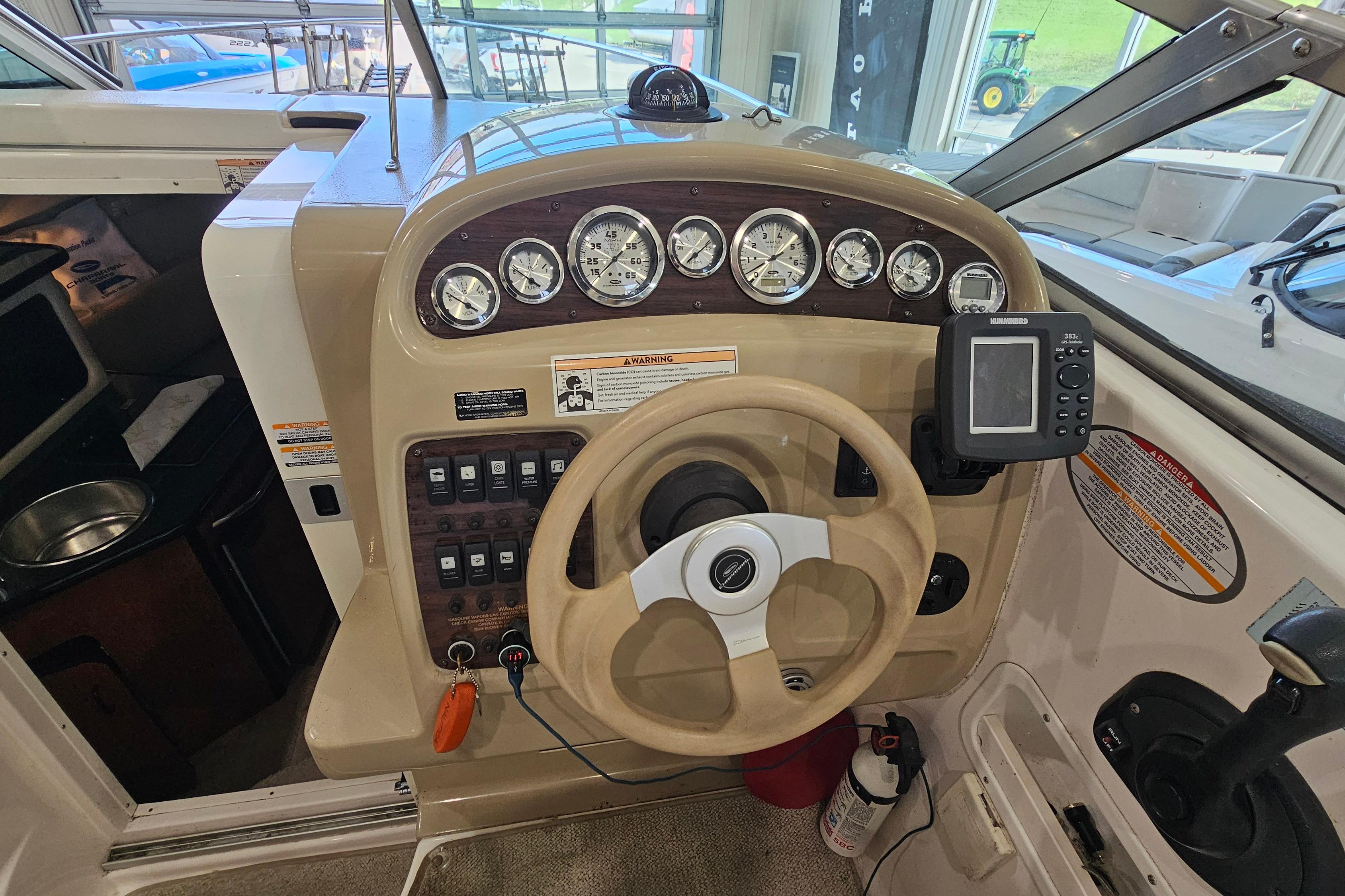 2001 Chaparral Signature 240 boat dashboard with gauges, steering wheel, and navigation equipment.