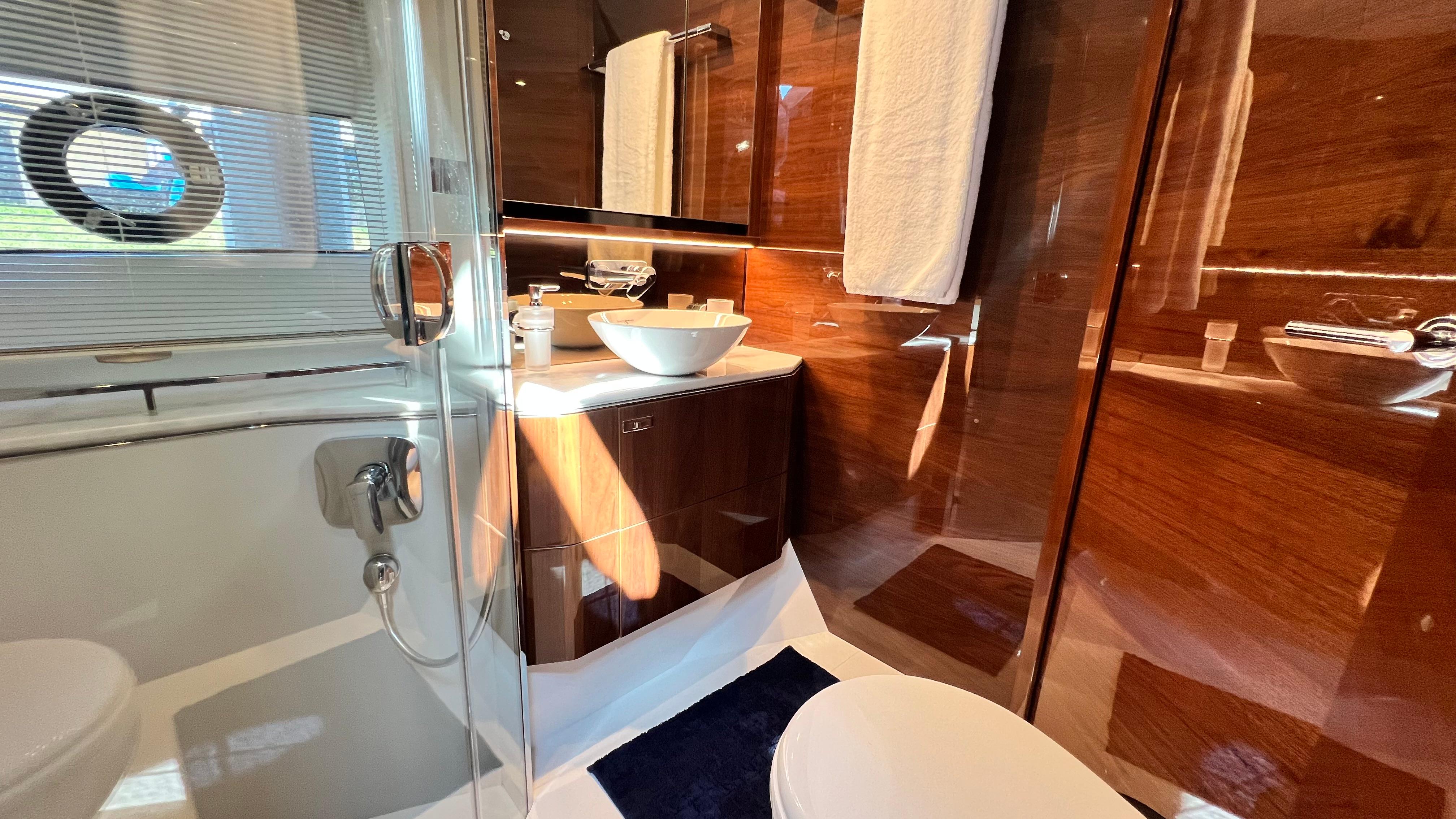 Luxurious bathroom in 2019 Princess F62 yacht with modern fixtures and elegant wood paneling.