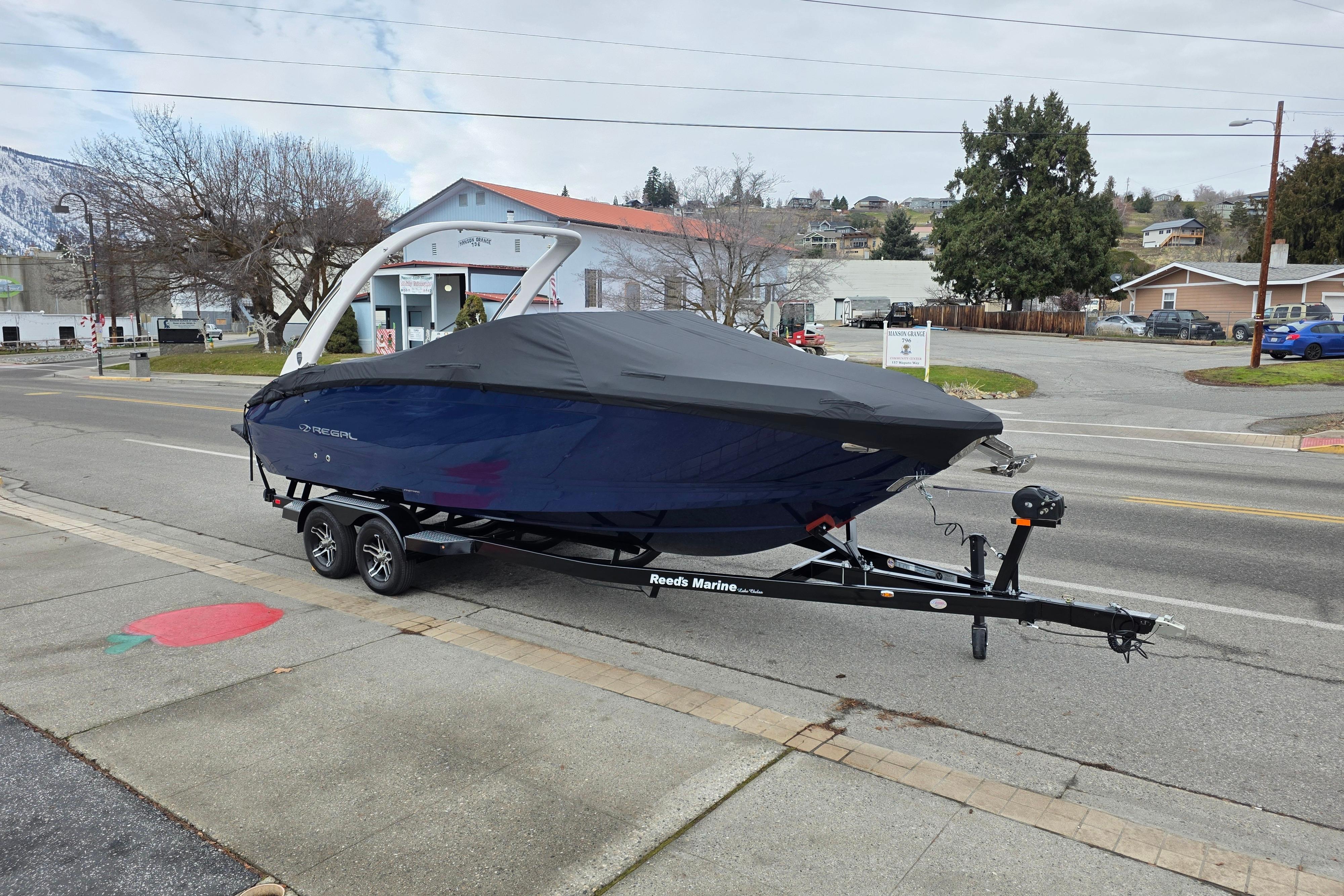 2026 Regal LS6 boat on trailer, covered, parked on street.