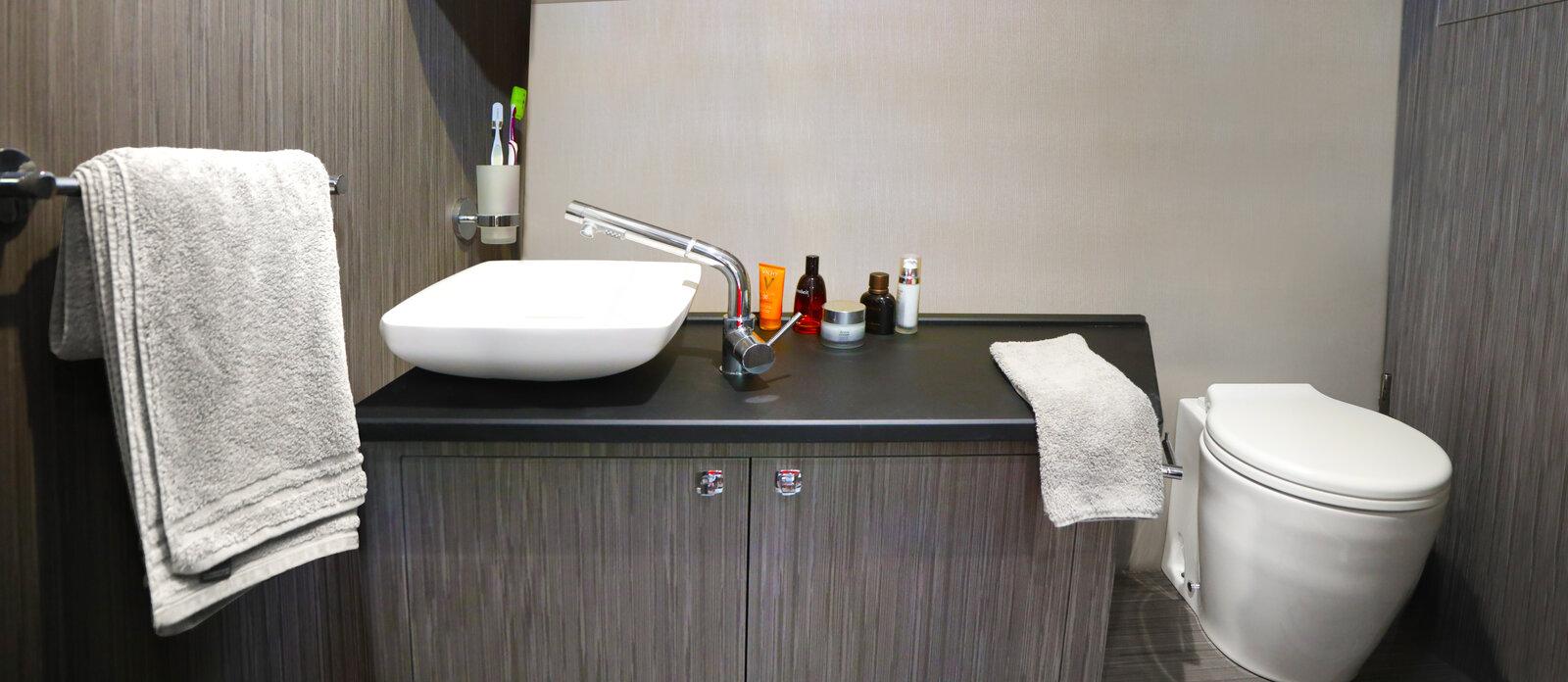 Modern bathroom in 2025 Ranieri NEXT 330 XL boat, featuring sleek sink and toilet.
