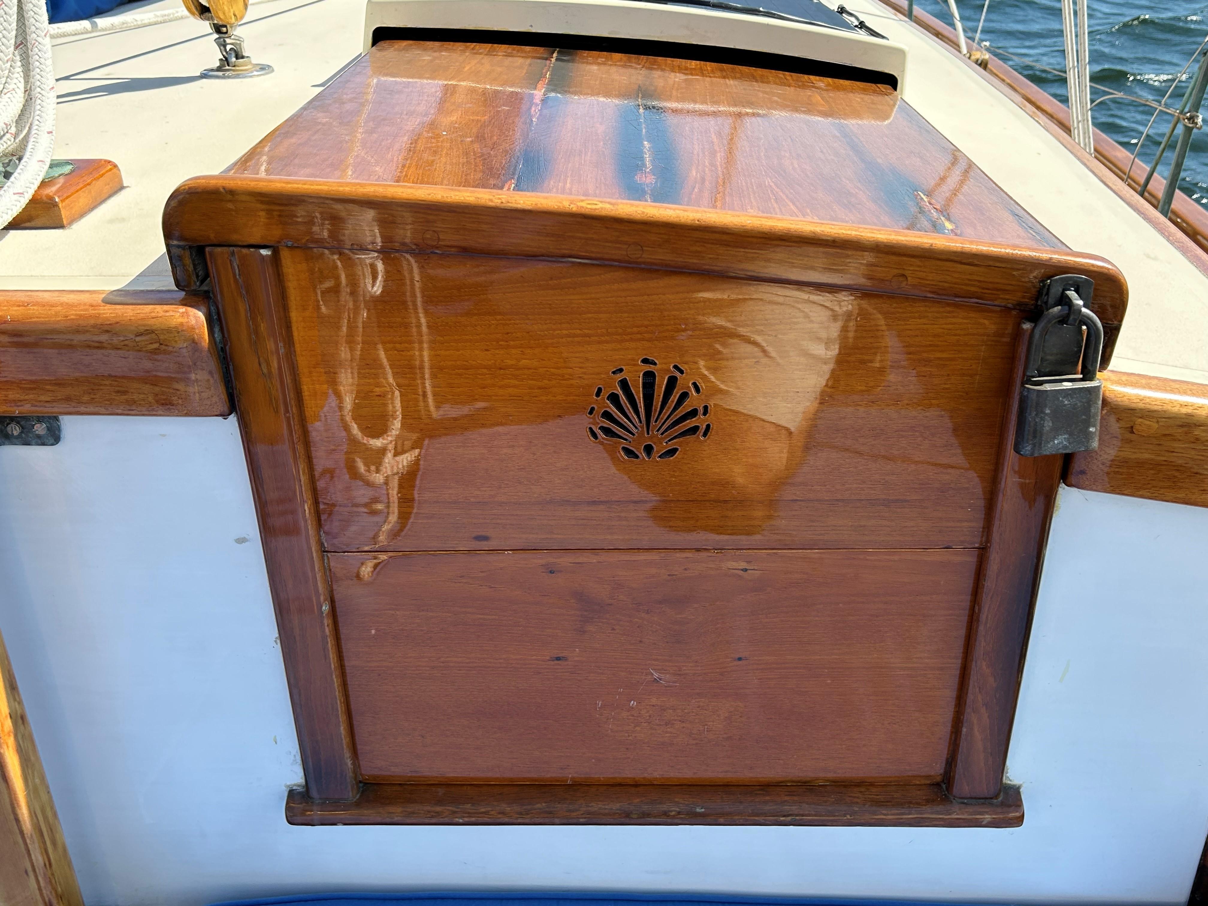 1985 Herreshoff Nereia Molly's Cove sailboat with polished wooden hatch and decorative carving.