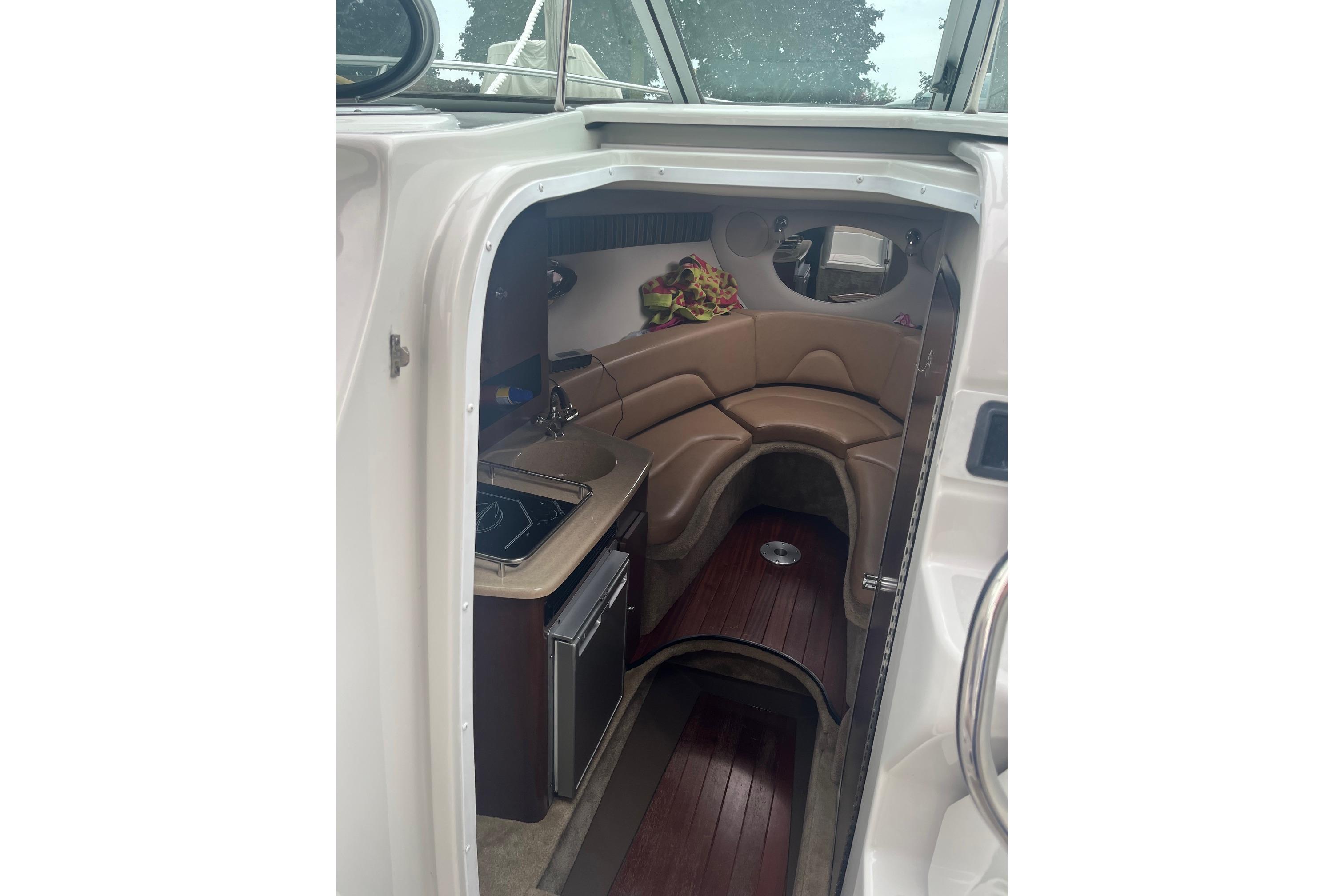 2016 Crownline 264 CR cabin interior with seating and kitchenette.
