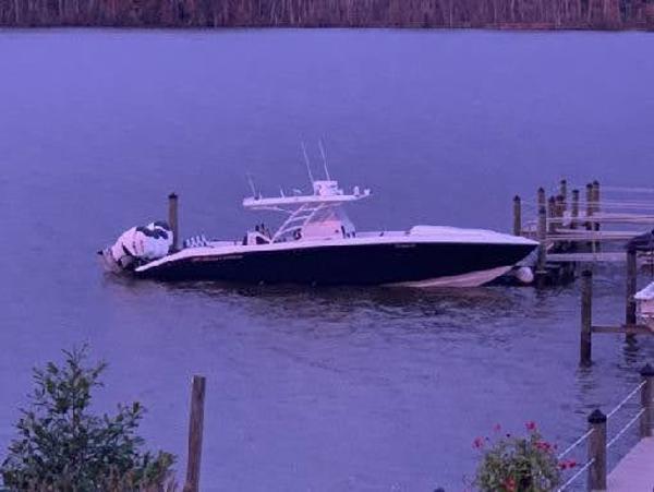 2019 Midnight Express 39 Cuddy boat docked on calm water at sunset.