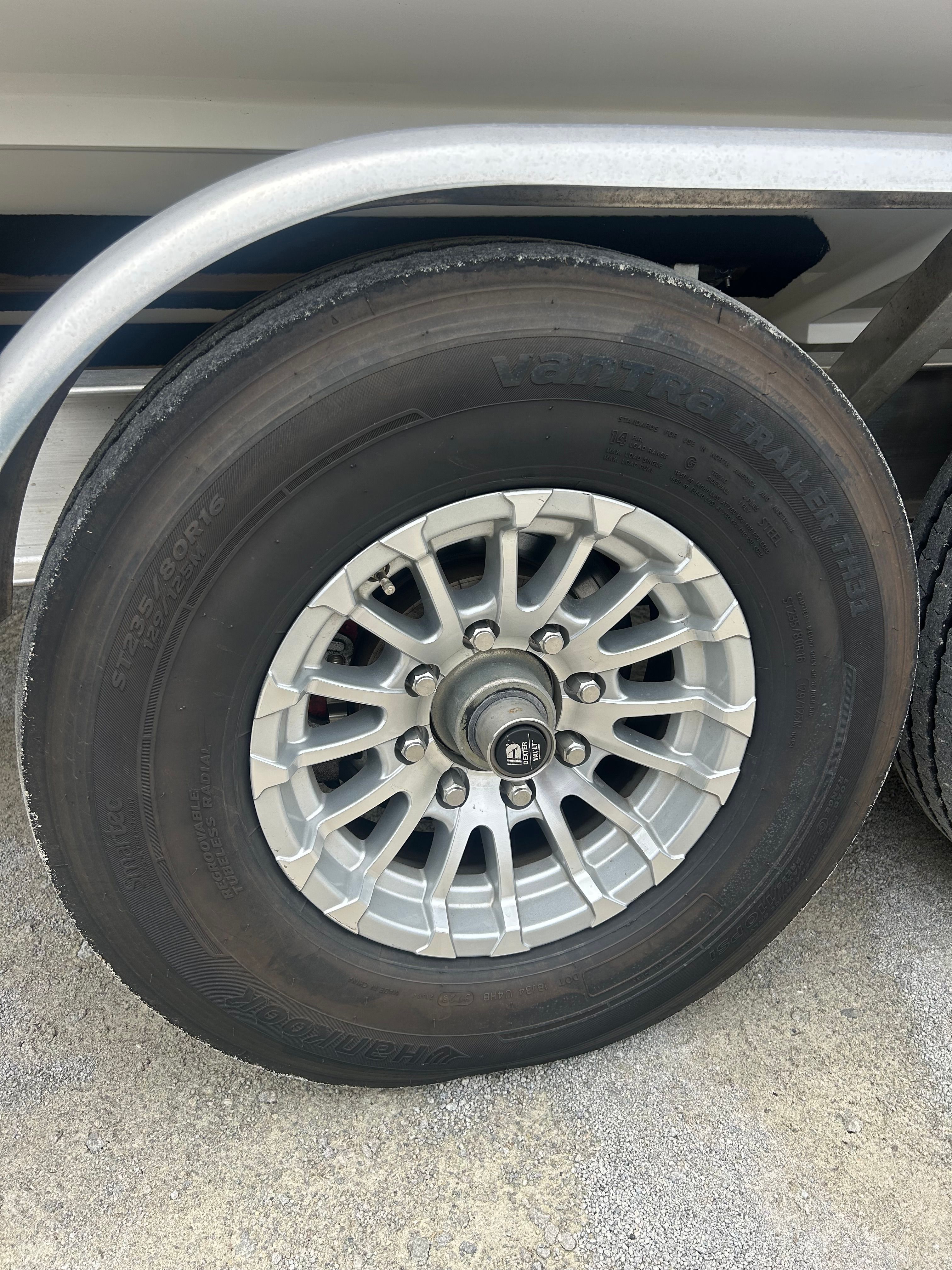Close-up of a boat trailer wheel with a silver rim.