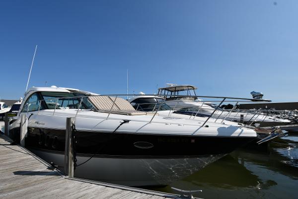 2010 Cruisers Yachts 390 Sports Coupe docked at marina under clear blue sky.