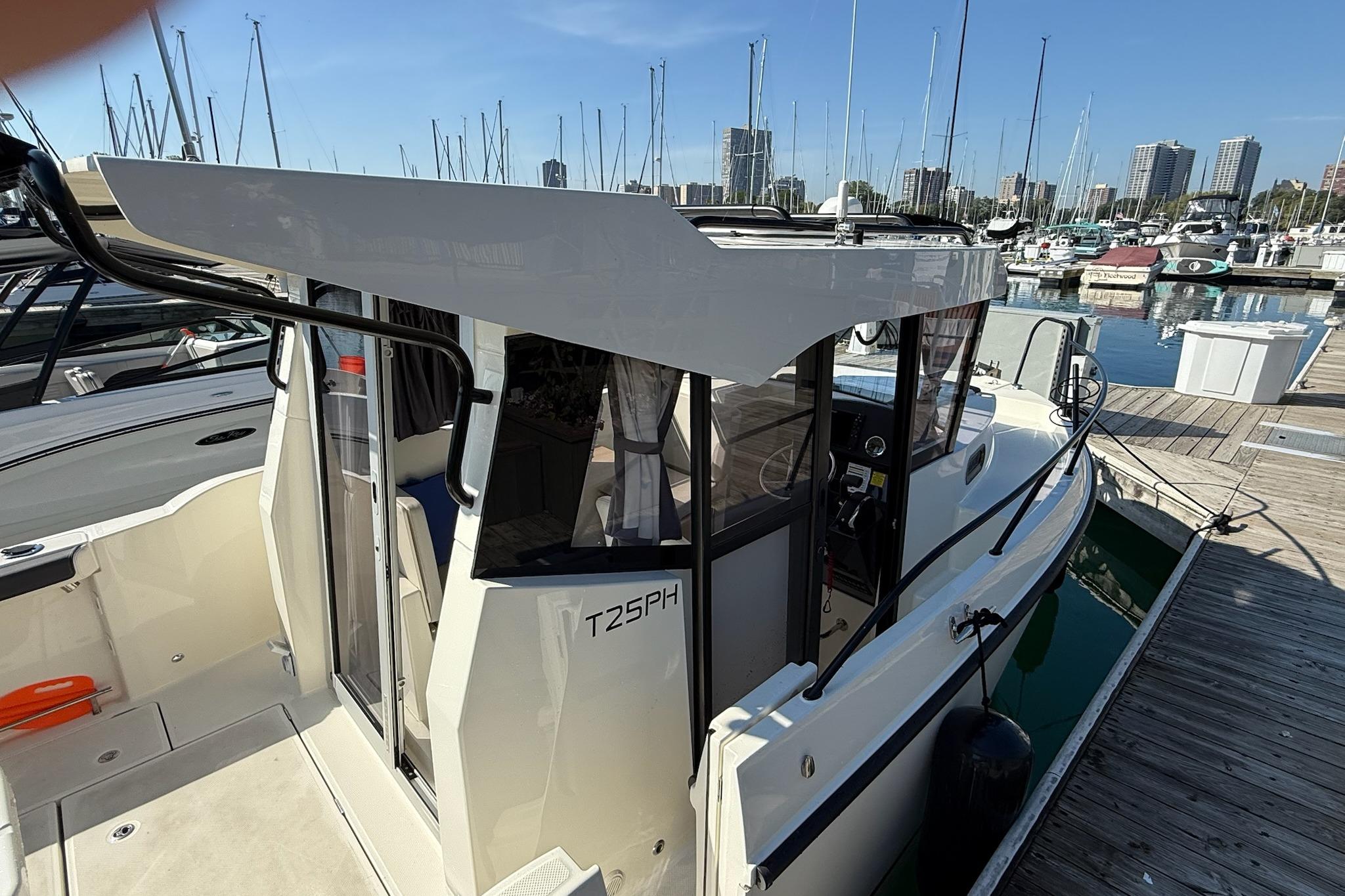 2024 Bayliner Trophy T25 Pilothouse docked at marina, showcasing sleek design and modern features.
