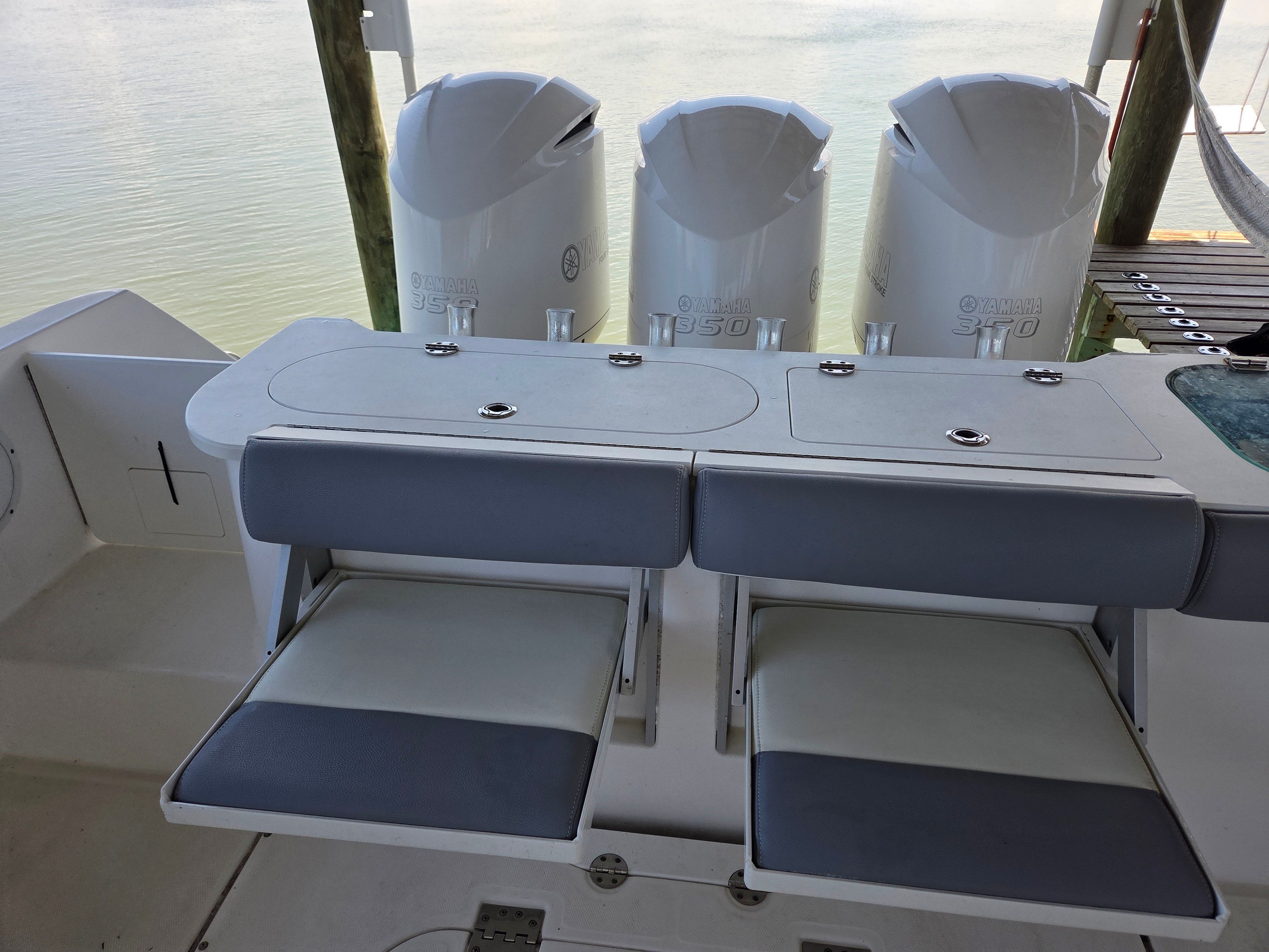 The image shows the stern area of a 2017 Everglades 355 Center Console boat with three engines.