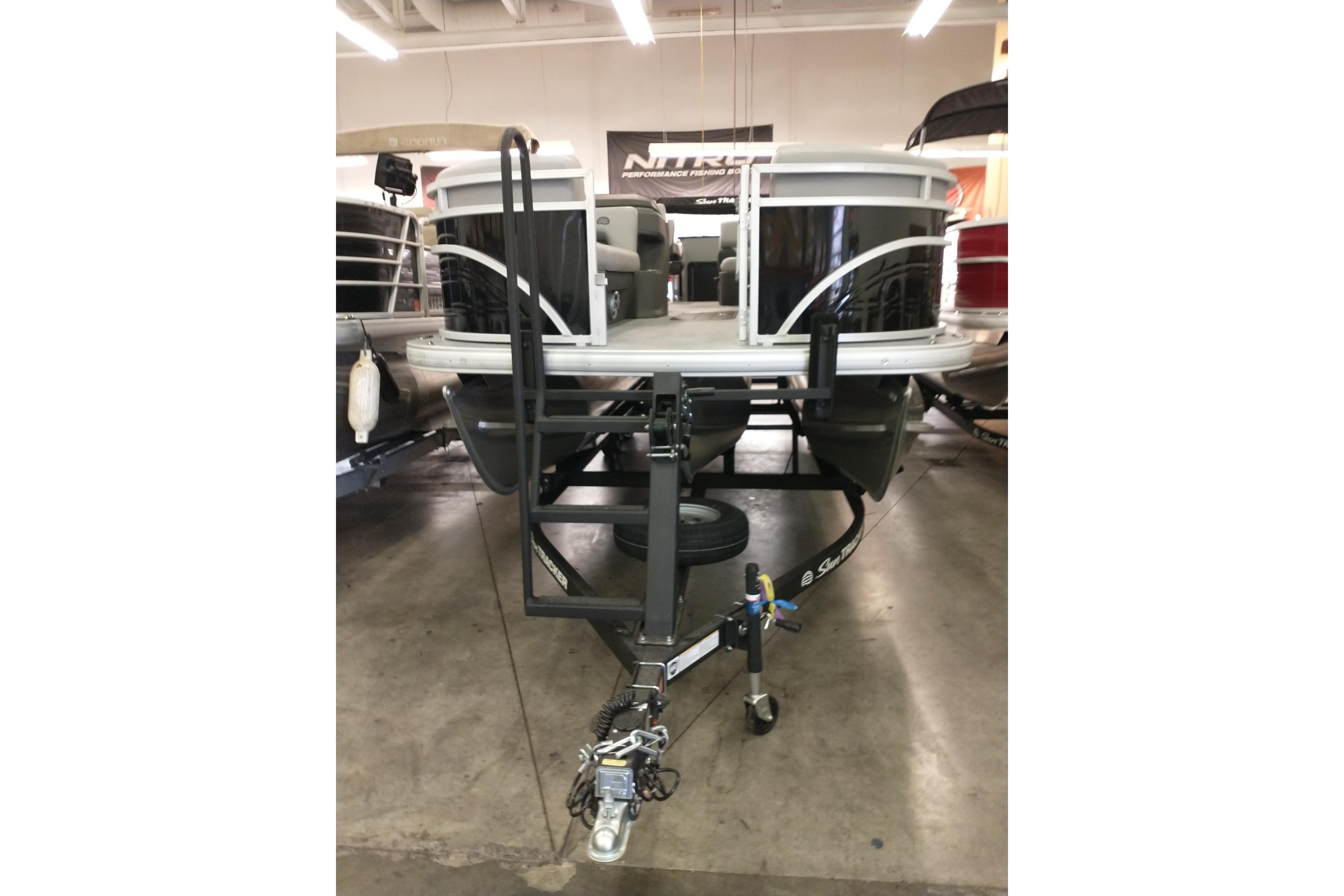 2026 Sun Tracker SportFish 22 XP3 pontoon boat on a trailer in a showroom.