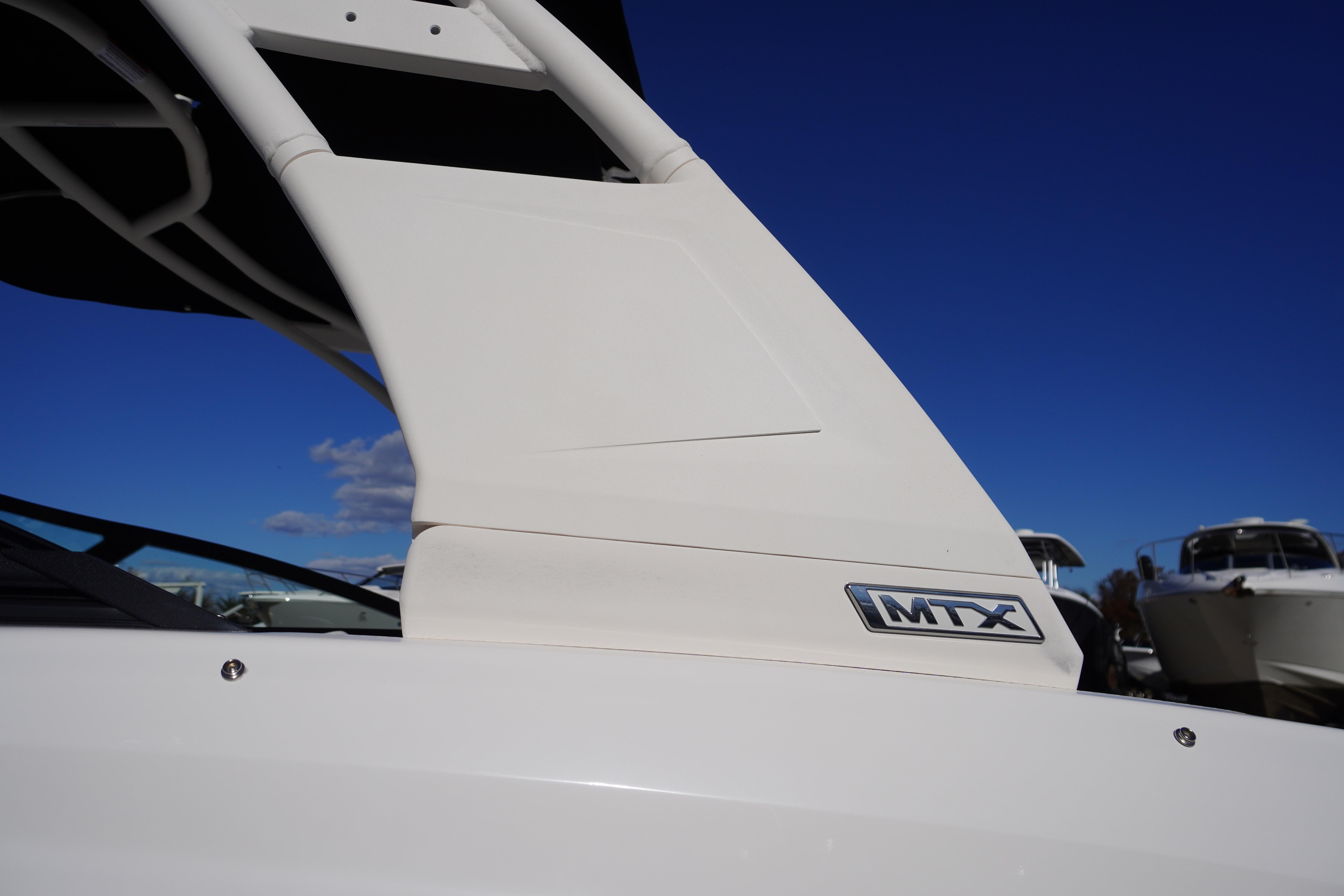 2026 Chaparral 23 SSi boat with MTX logo, under clear blue sky.