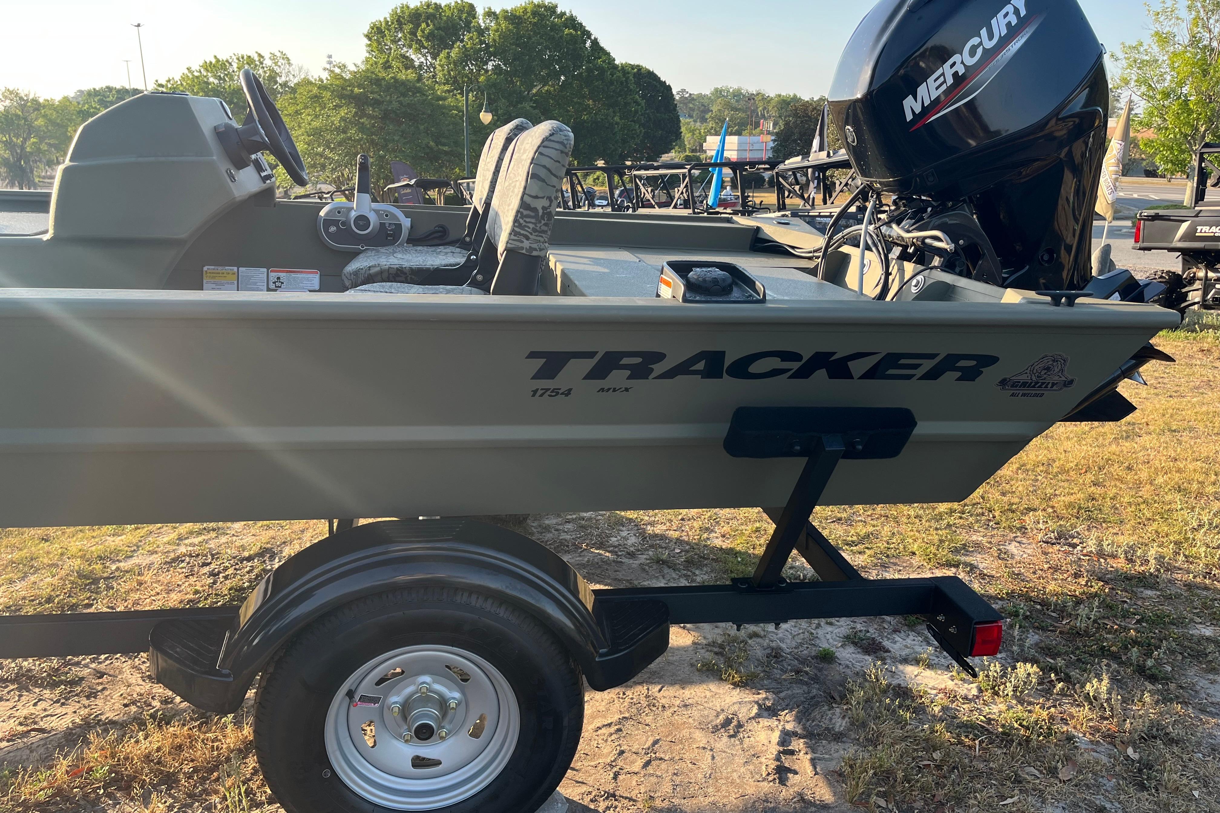 2026 Tracker Grizzly 1754 SC boat with Mercury engine on trailer, parked outdoors.