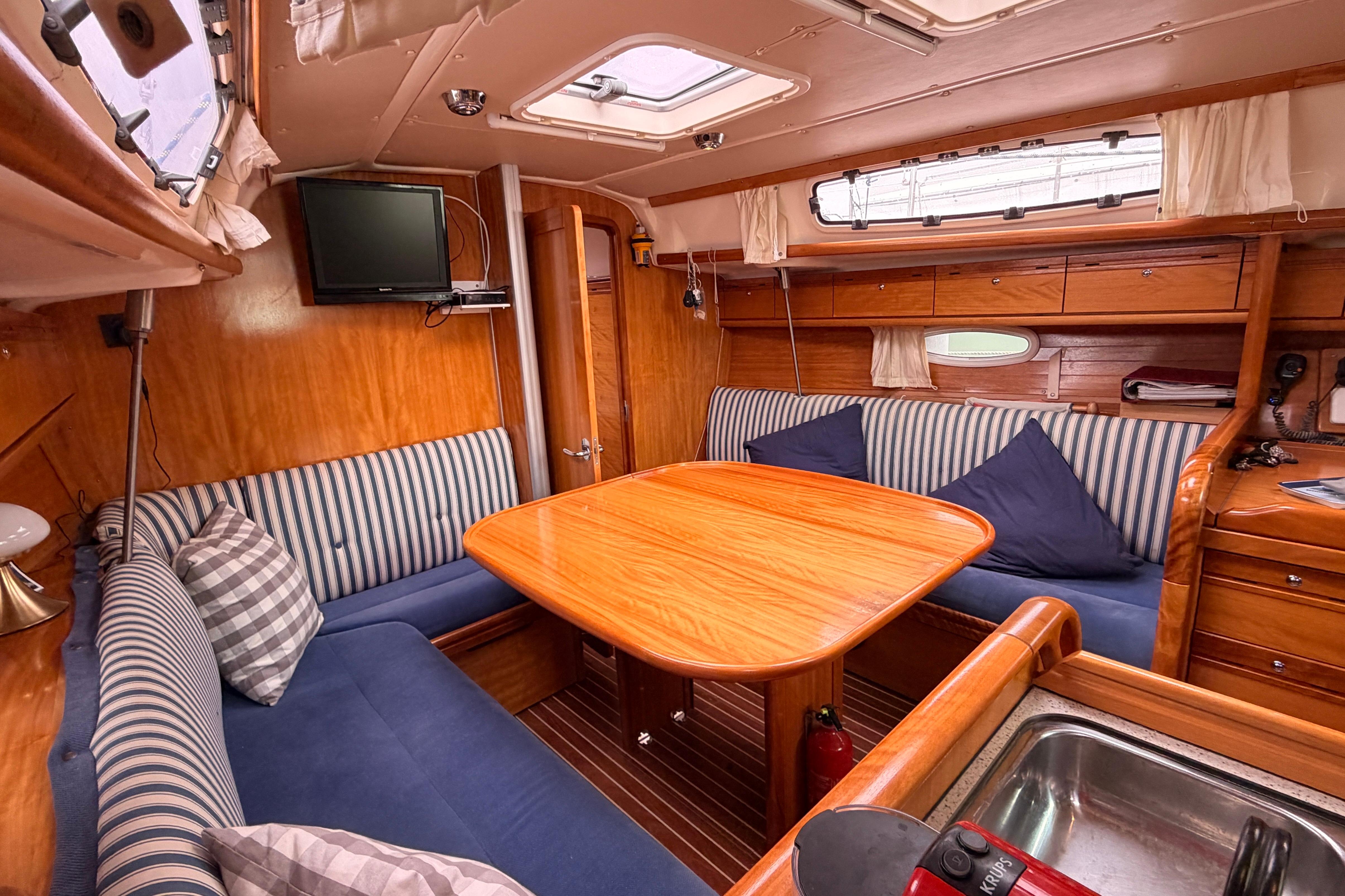 Interior of 2009 Bavaria 34 Cruiser yacht with cozy seating and wooden table.
