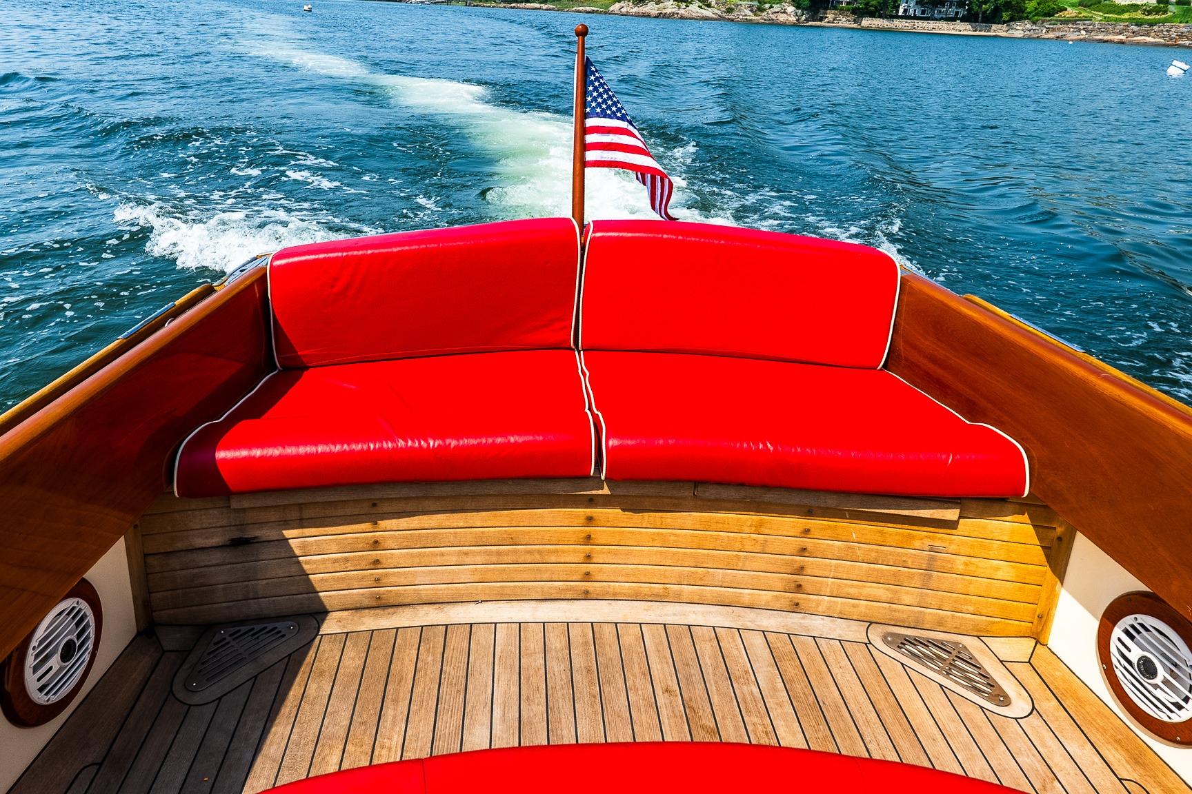 2005 Hinckley Talaria 29R boat with red seating, cruising on a sunny day.