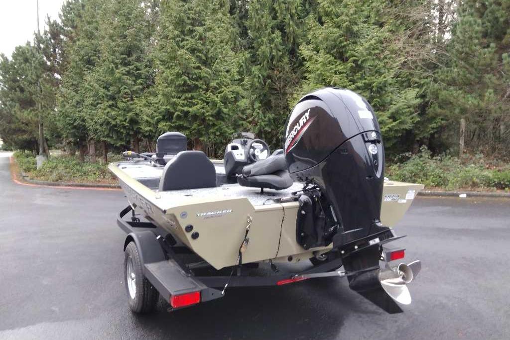 2026 Tracker Pro Team 195 boat with Mercury engine, parked outdoors near trees.