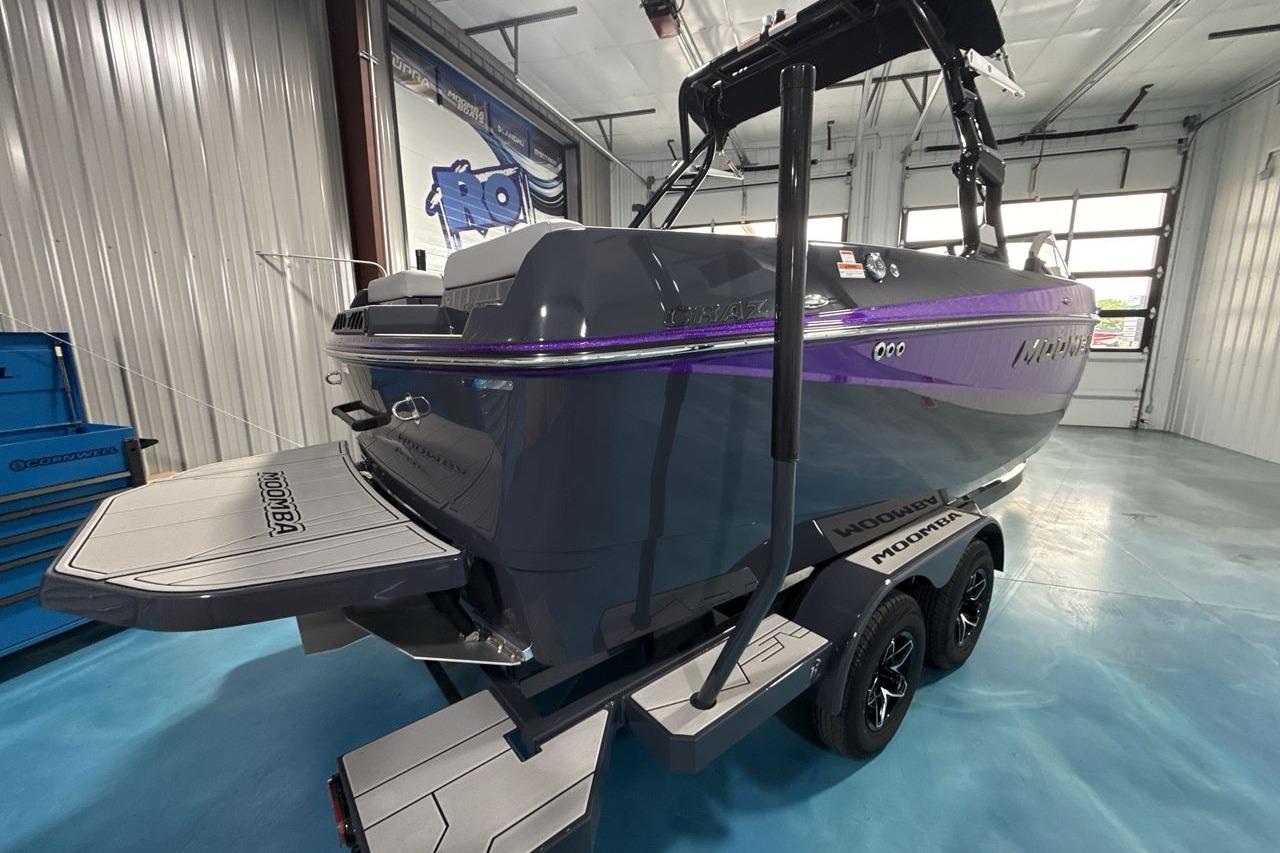 The image shows a modern 2026 Moomba Craz boat in a storage facility.