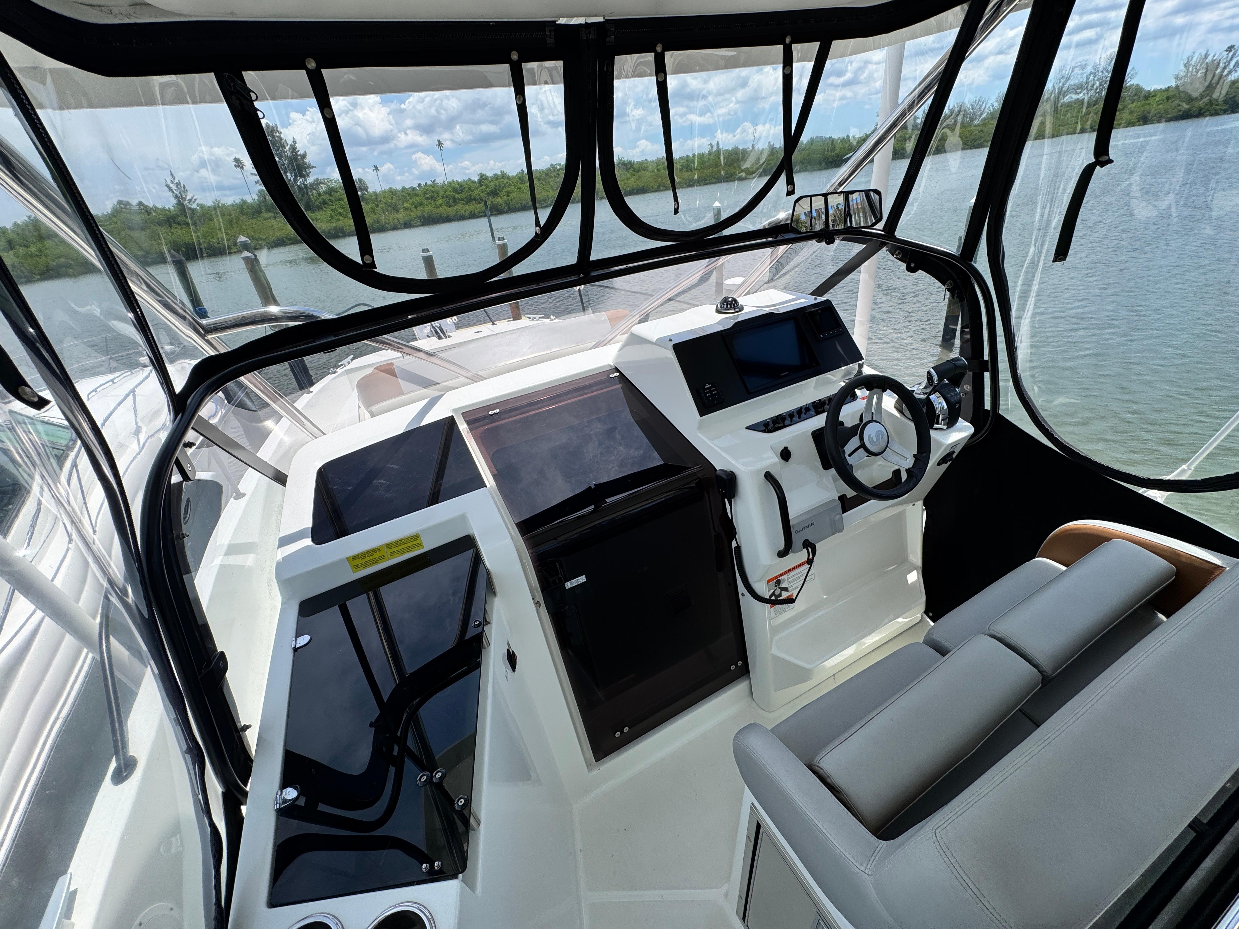 2022 Beneteau Flyer 9 SUNdeck cockpit with modern controls and seating, overlooking serene waters.