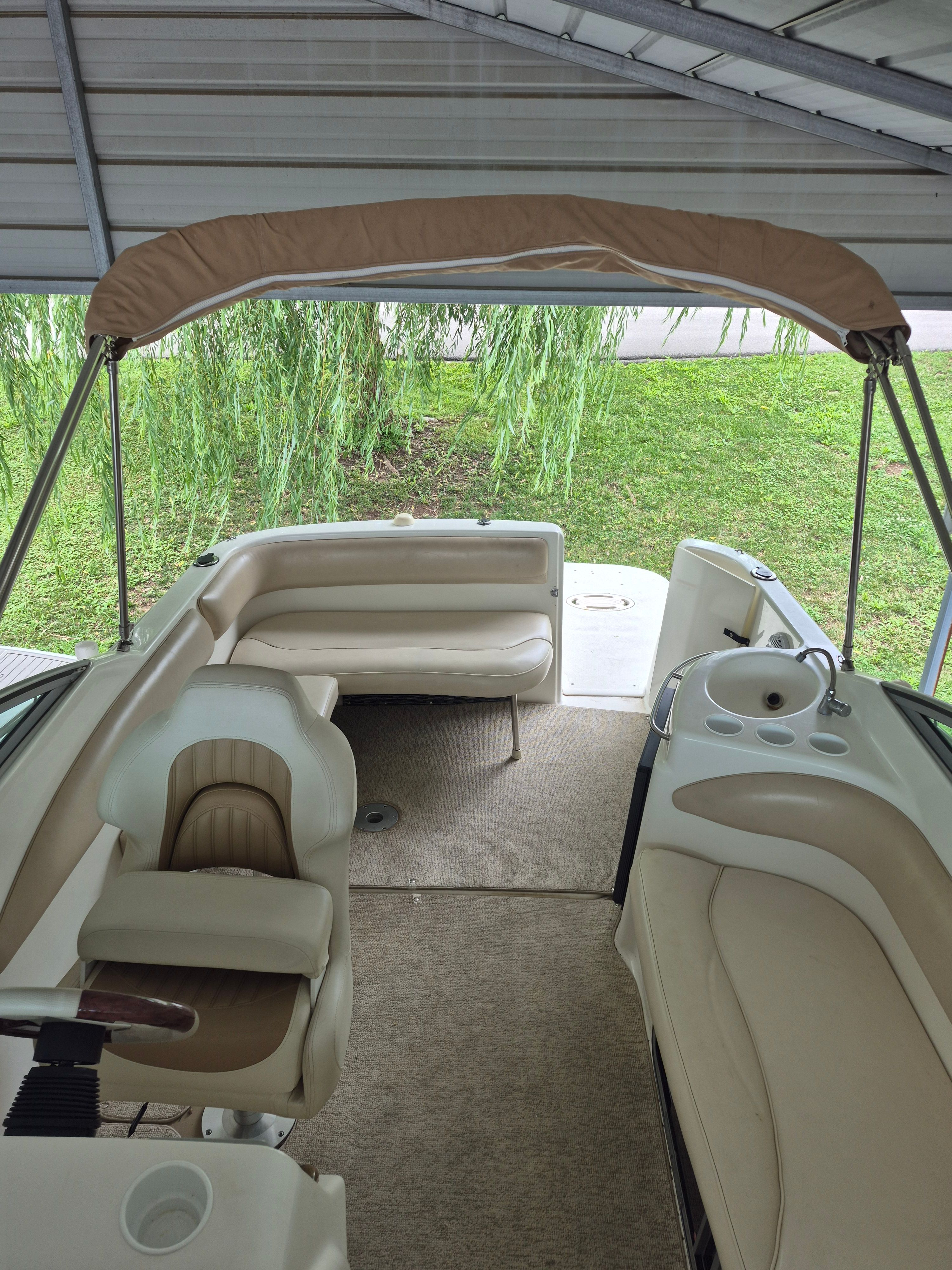 Interior view of a 2004 Larson Cabrio 274 with beige seating and carpeted floor.