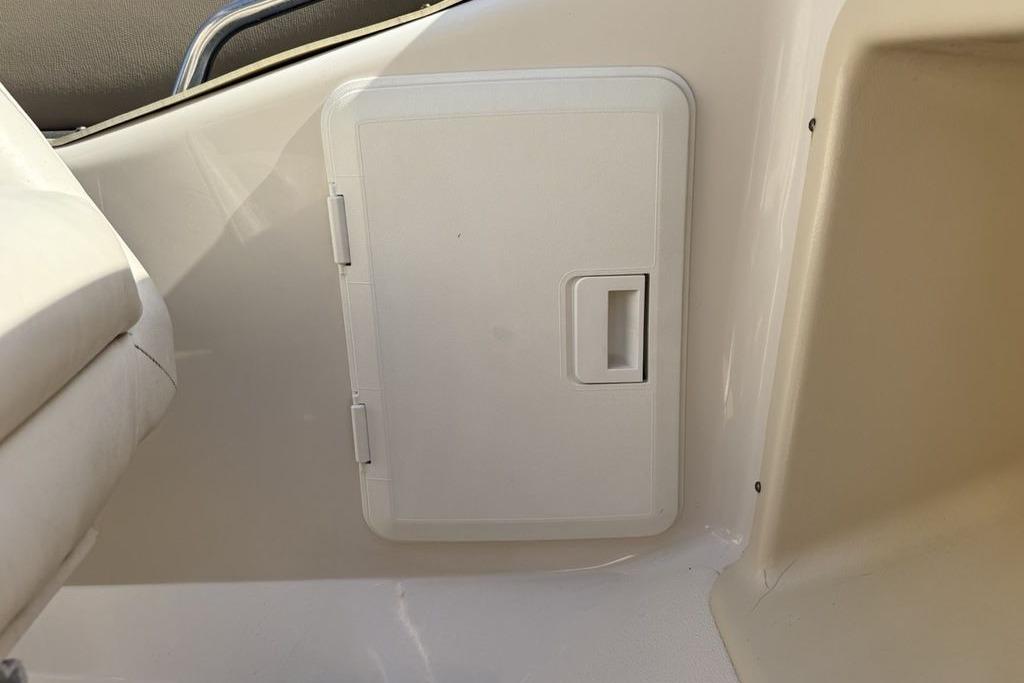 White storage compartment on a 1999 Glastron GT 225 boat interior.
