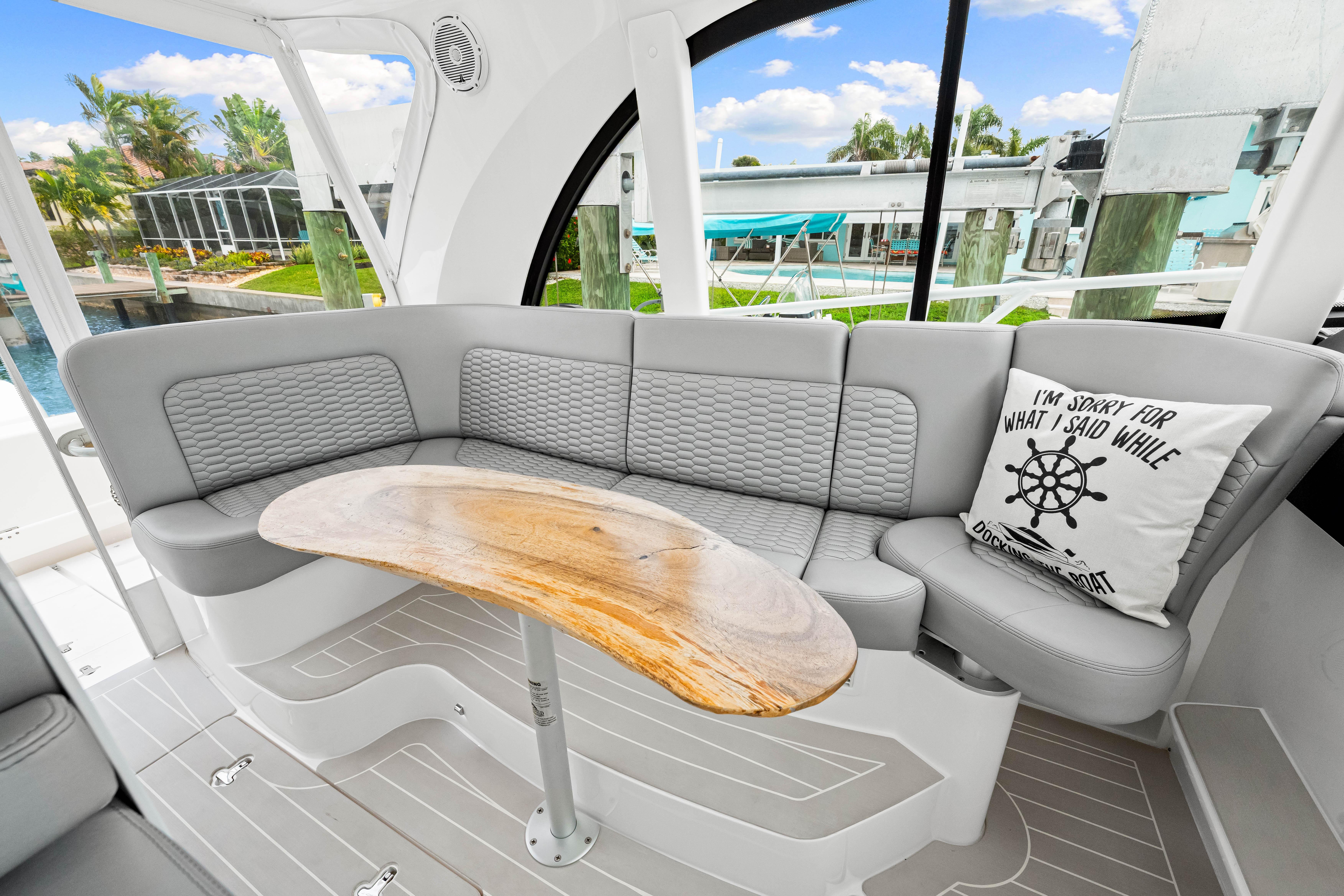 Luxurious seating area on a 2019 Intrepid 410 Evolution yacht with a wooden table.