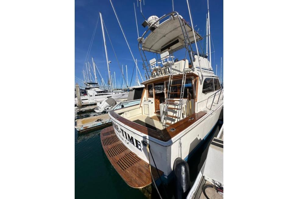 1985 Egg Harbor 33 Sedan boat docked at marina, showcasing rear deck and upper helm.