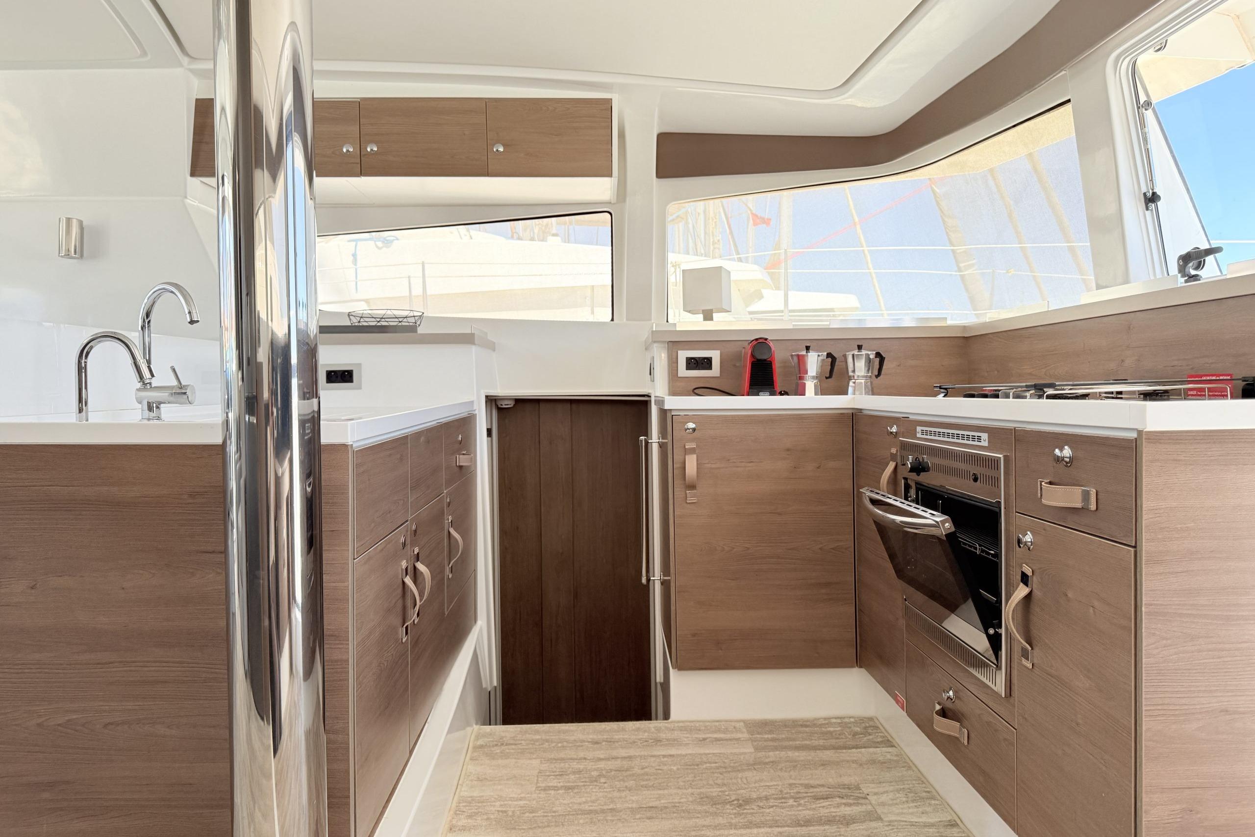 Modern kitchen interior on 2023 Bali 4.2 yacht with wood cabinets and stainless steel appliances.