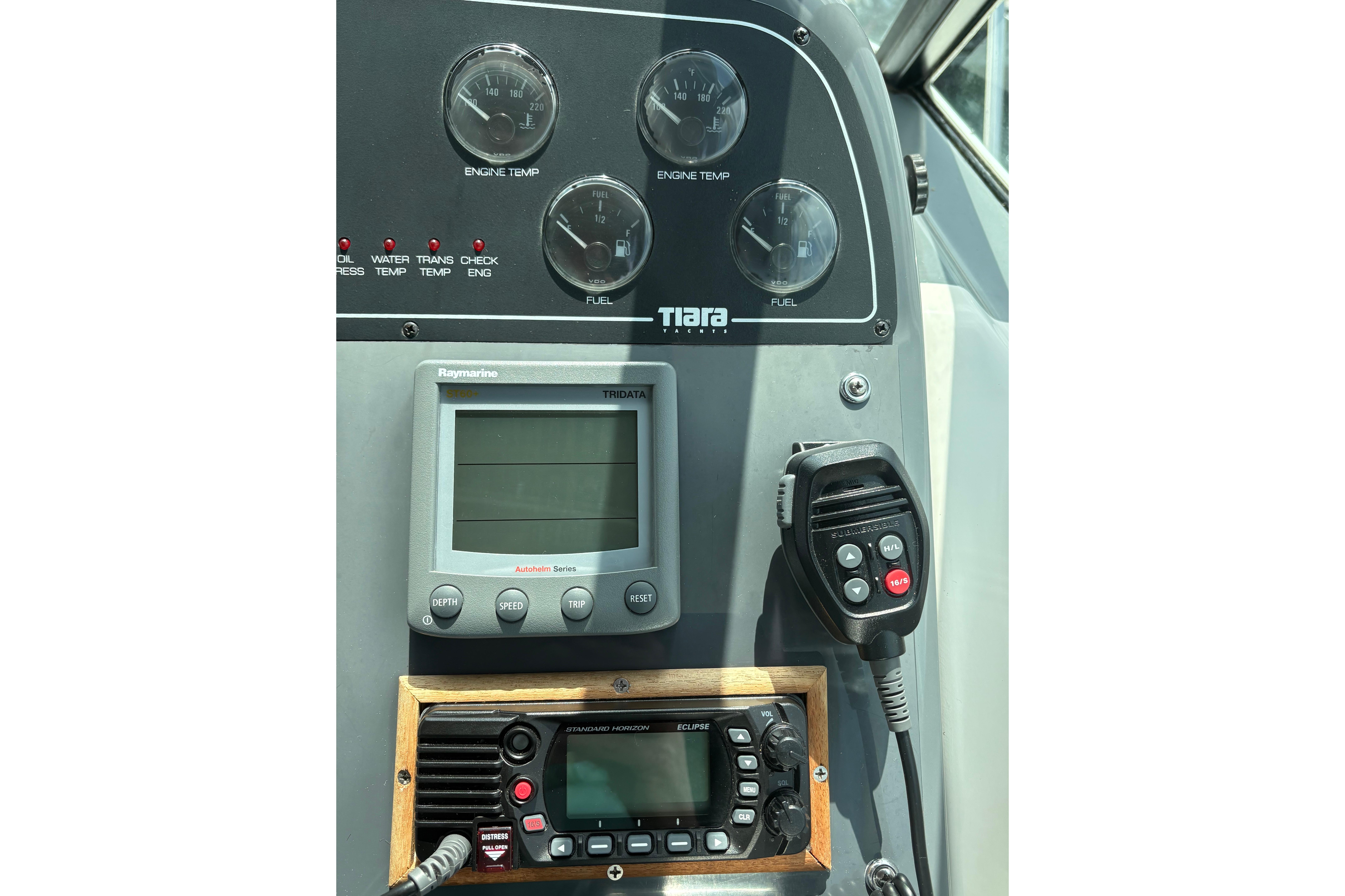Control panel of a 1999 Tiara Yachts 3100 Open, featuring gauges and communication devices.