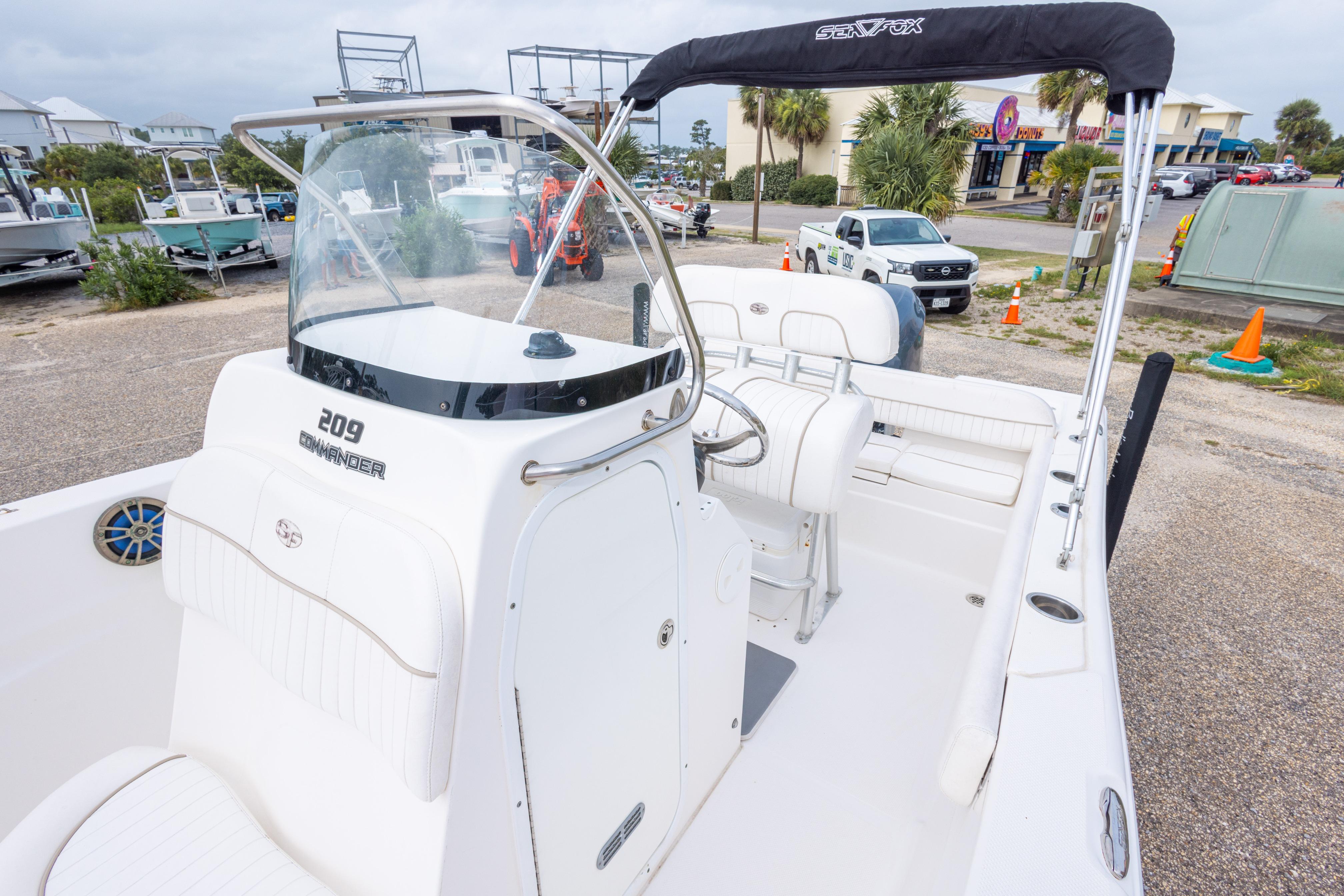 2014 Sea Fox 209 Commander boat with white interior and T-top in a marina setting.