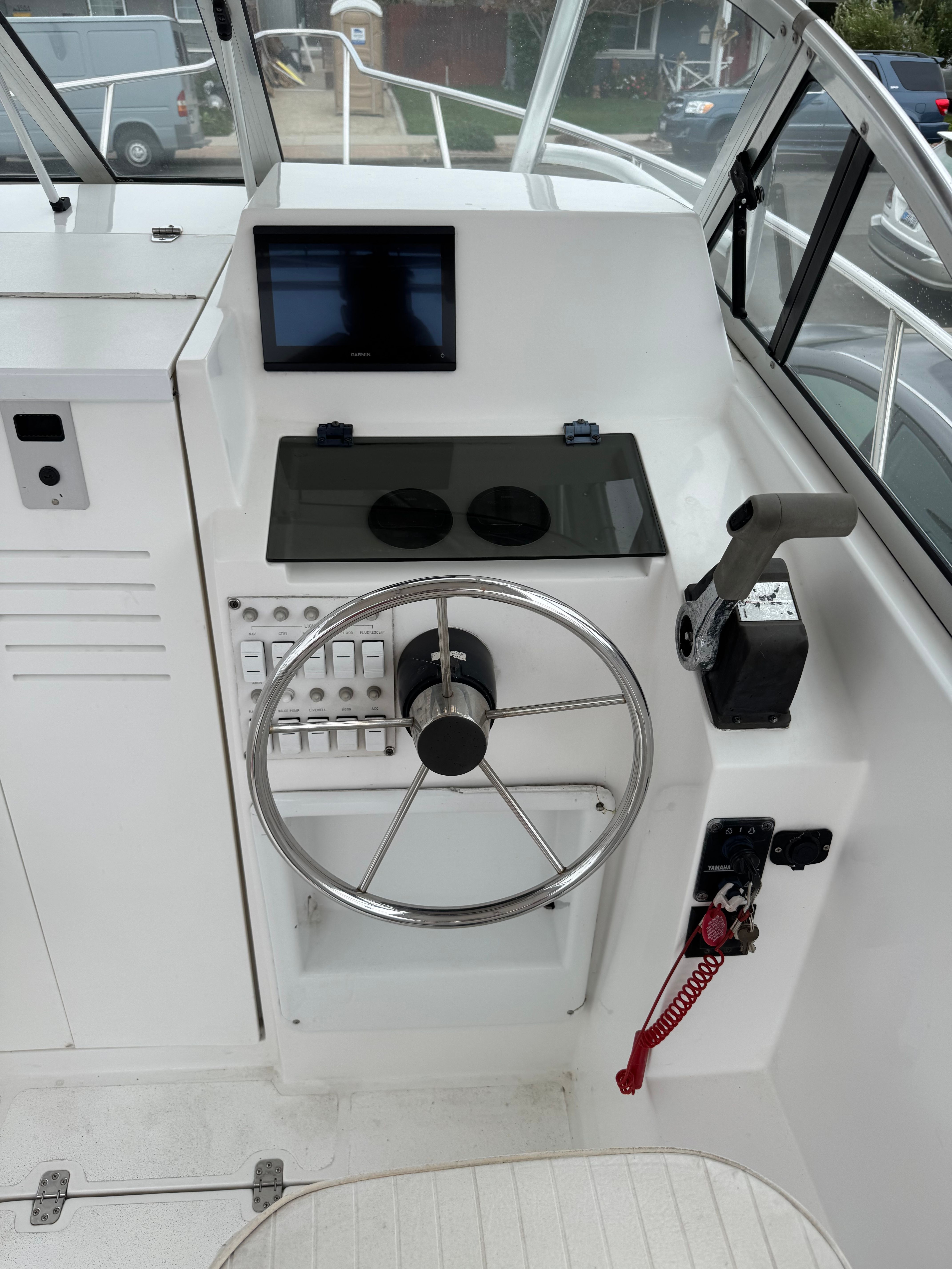 The image shows the helm of a 1999 Cobia Walkaround boat with a modern steering console.