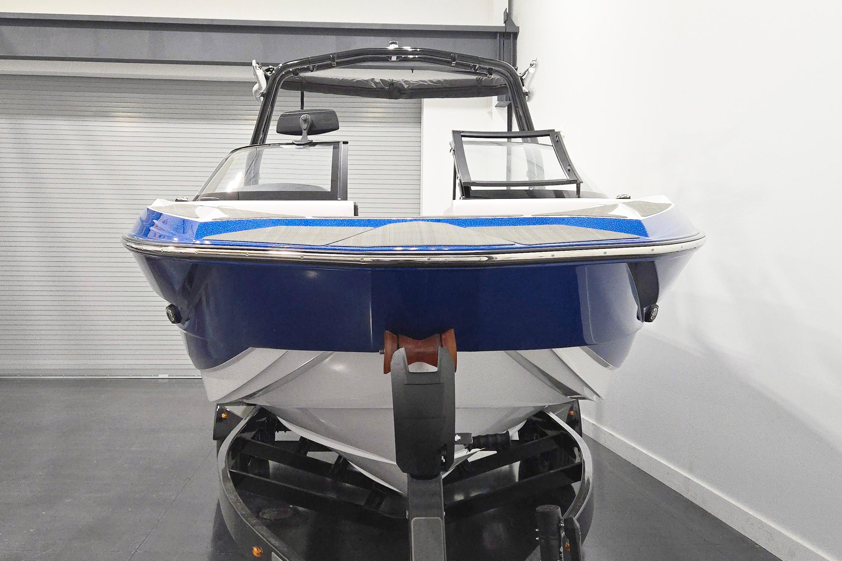 2026 Supreme S220 boat in showroom, blue and white design, on trailer.