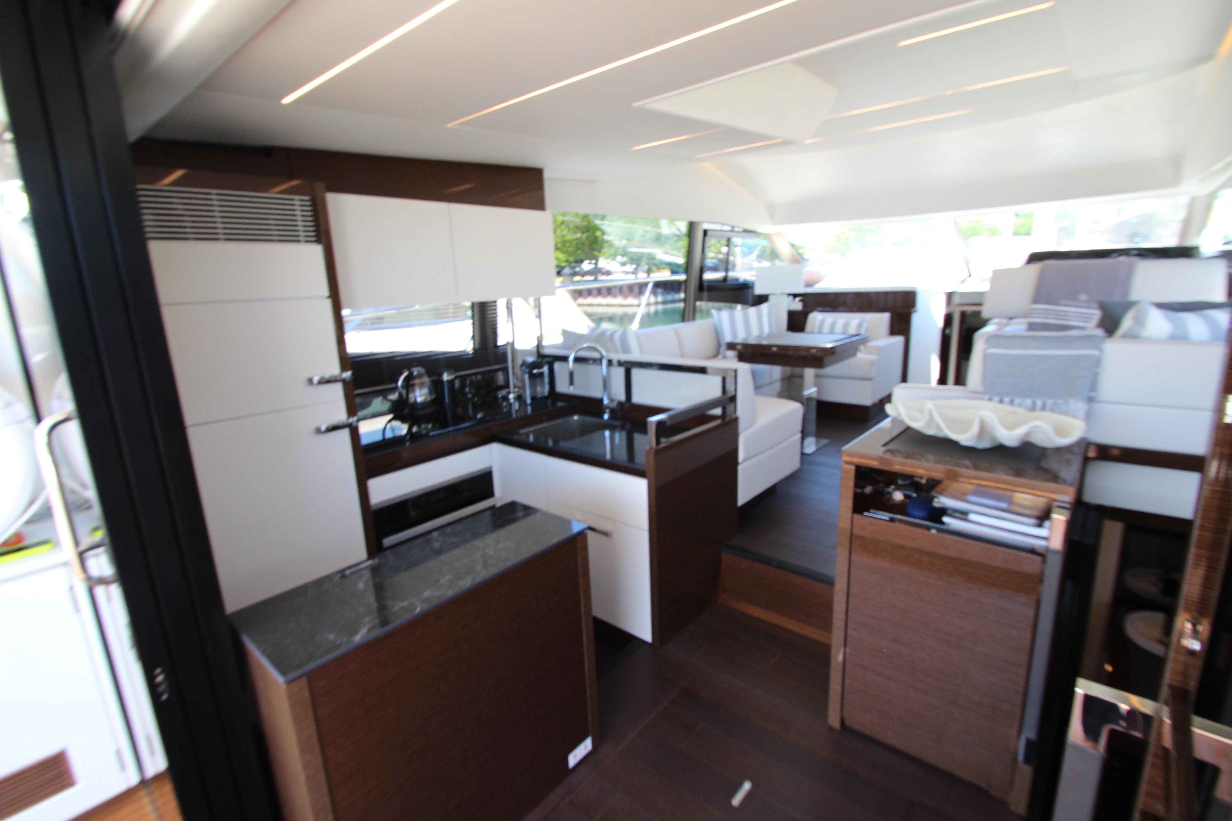 Luxurious interior of 2022 Prestige 520 yacht featuring modern kitchen and seating area.