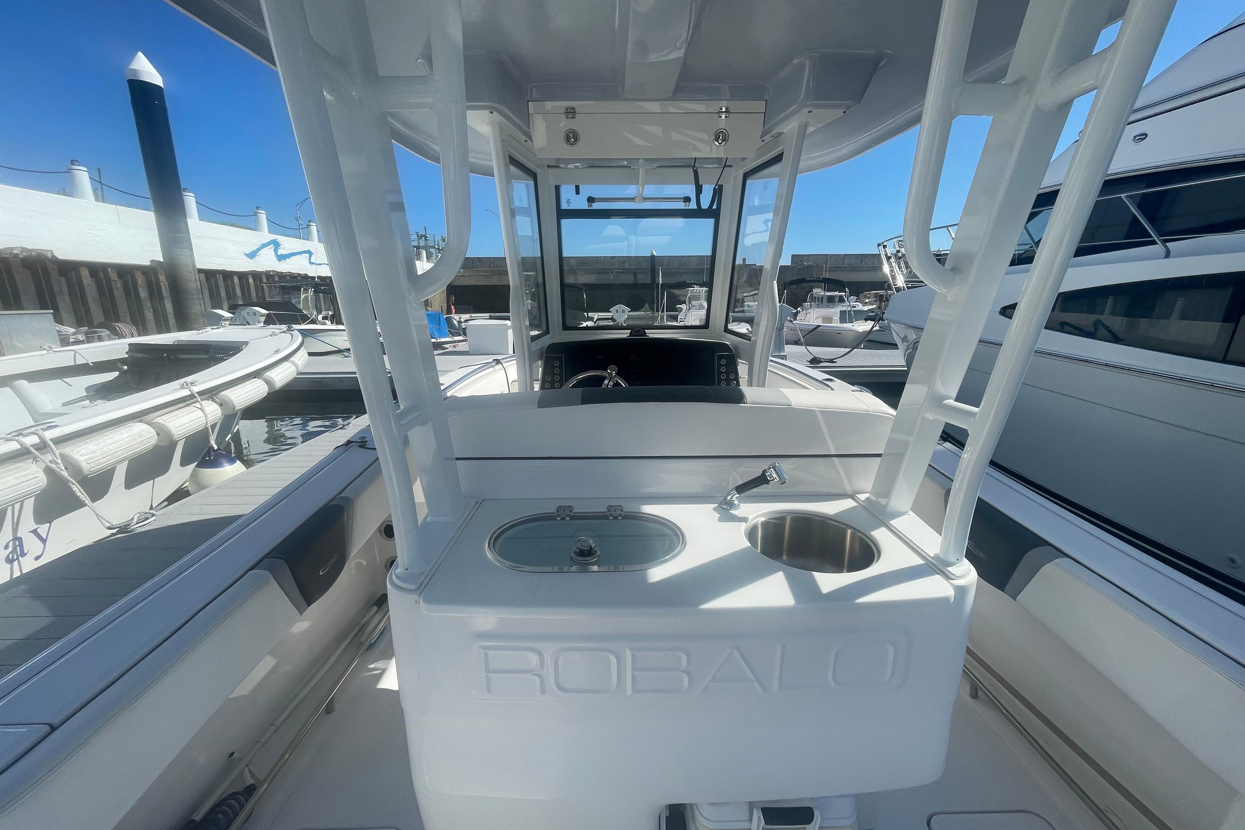2023 Robalo R270 Center Console boat docked, showcasing helm and seating area.