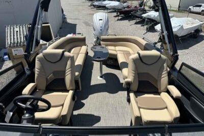 2025 SunCatcher Amara boat interior with beige seating and central table.