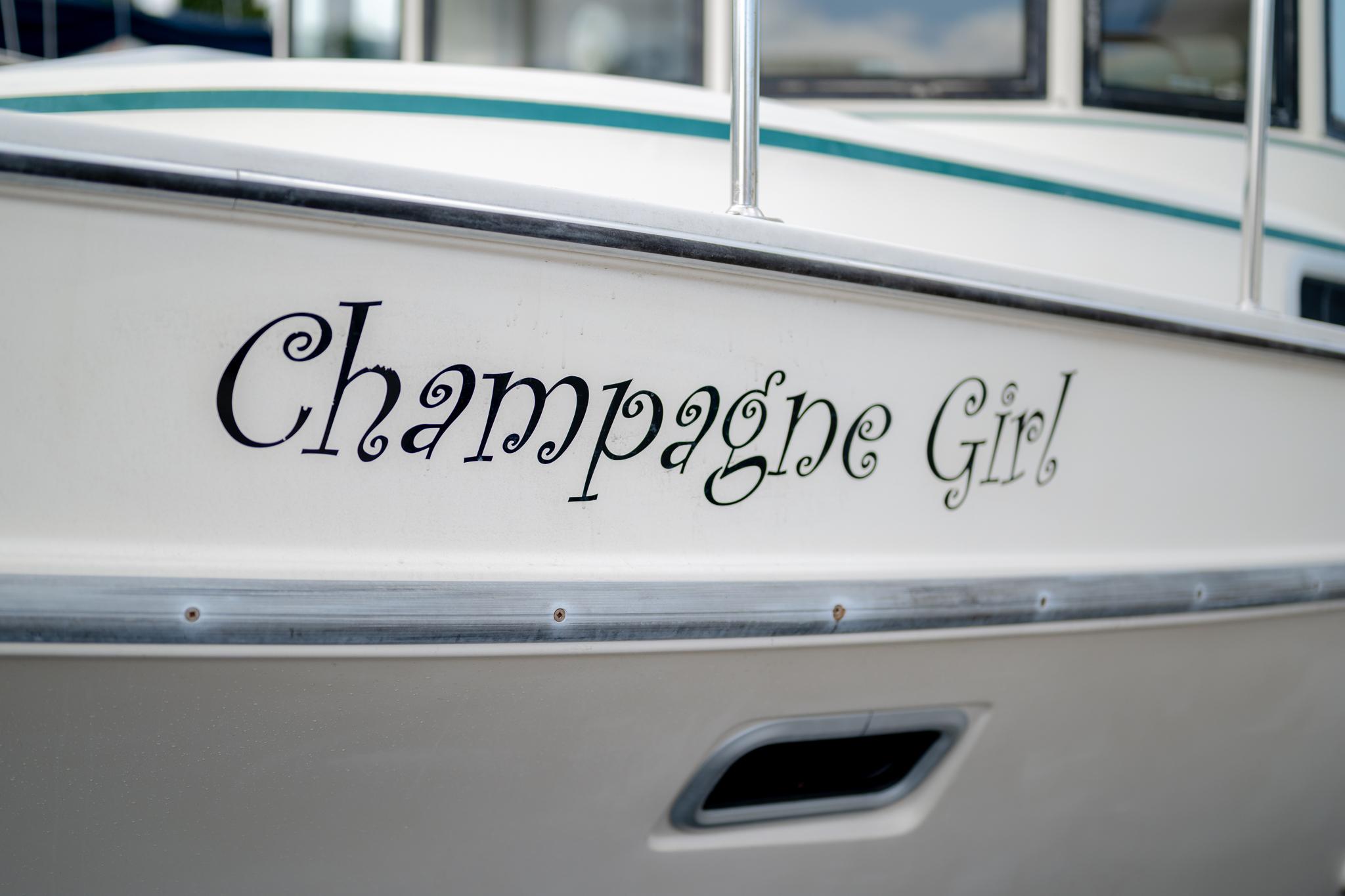 Close-up of "Champagne Girl" boat name on 1996 Camano 31.
