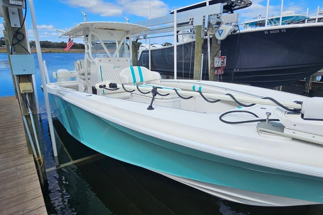 2002 Yellowfin 31 Center Console boat docked, featuring a sleek turquoise and white design.