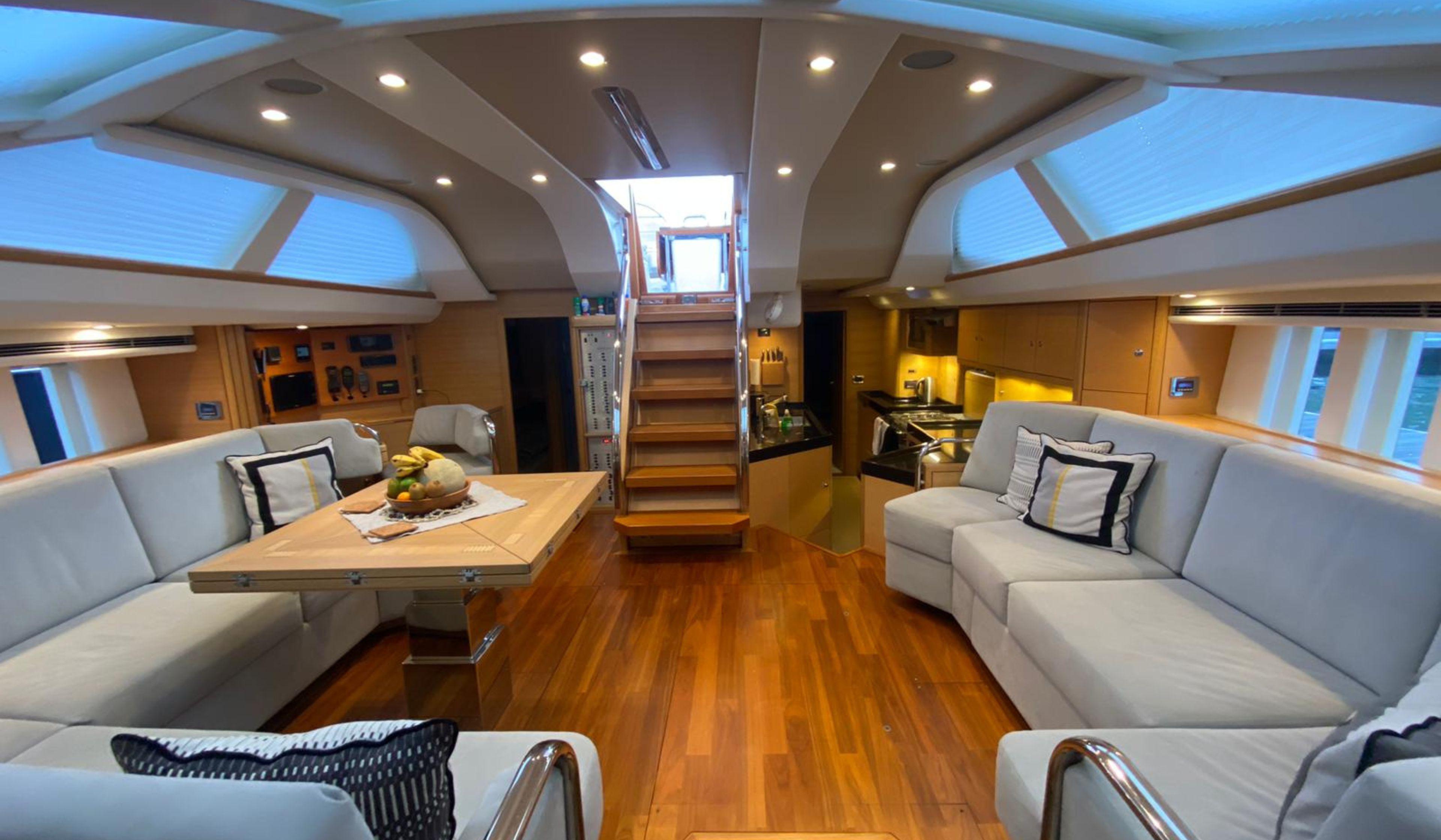 Luxurious interior of a 2016 Oyster 625 yacht with elegant seating and wooden flooring.