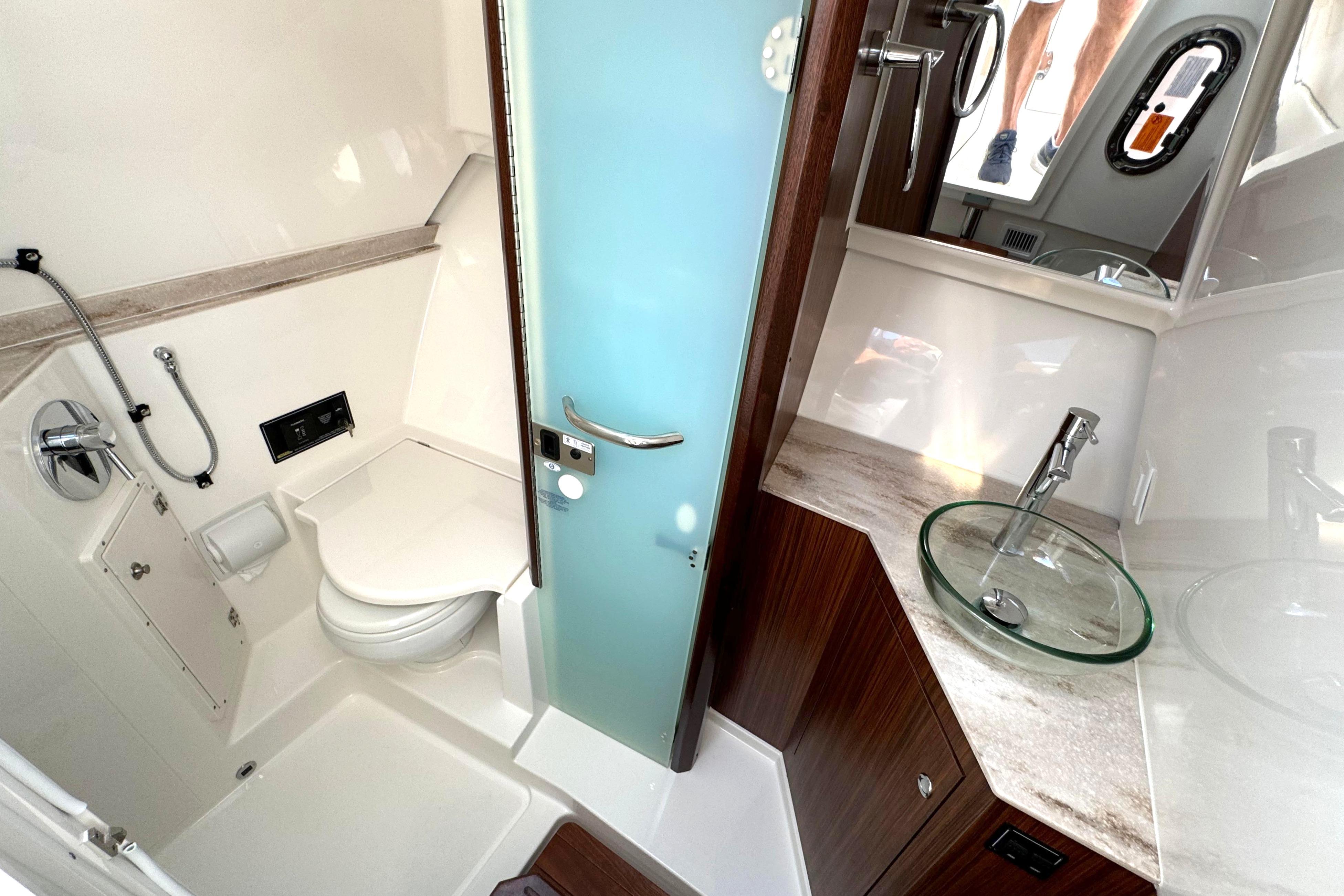 2021 Pursuit DC 365 boat bathroom with modern fixtures and glass sink.