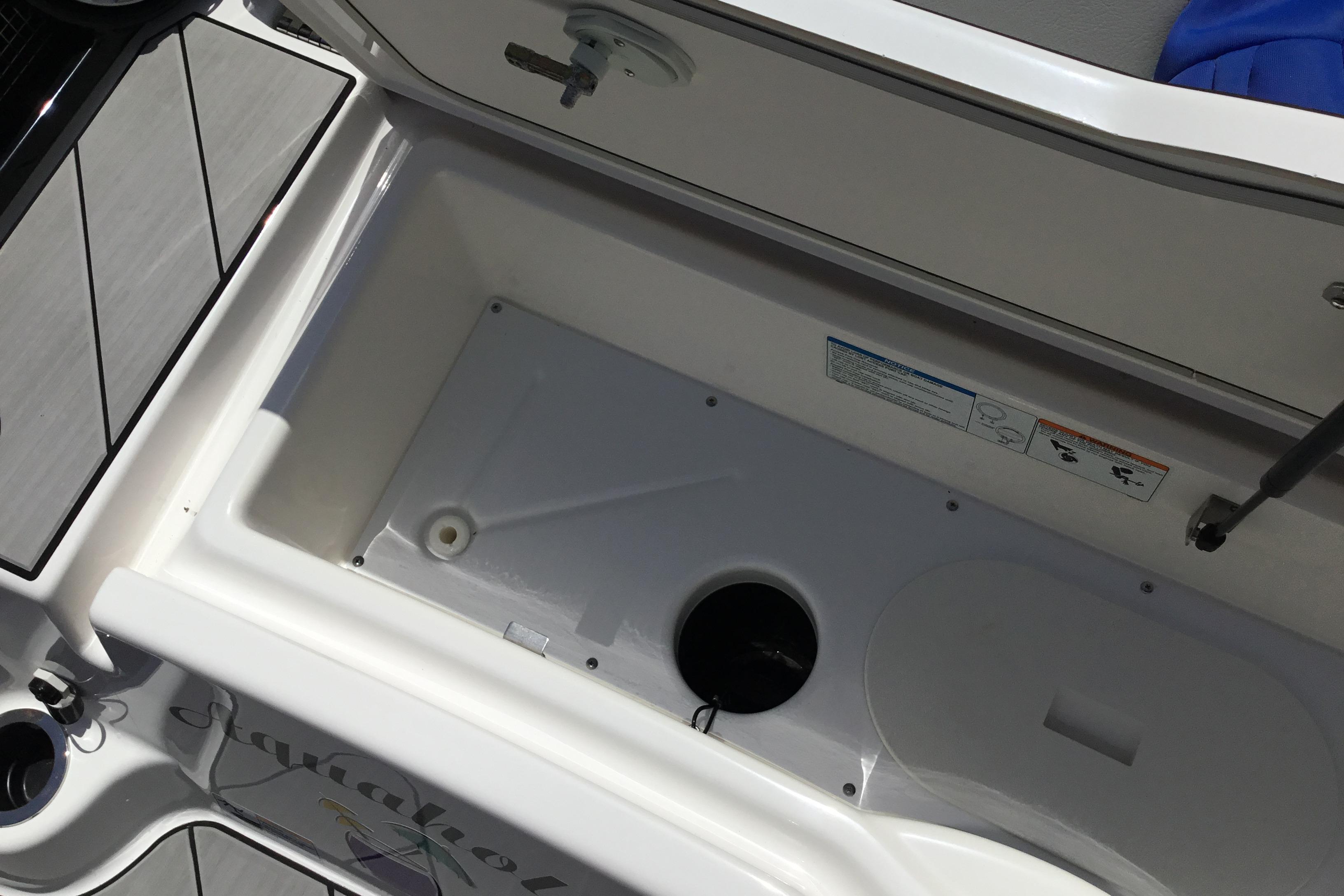 Open storage compartment on 2023 Yamaha Boats 252XE, showcasing interior space and design.