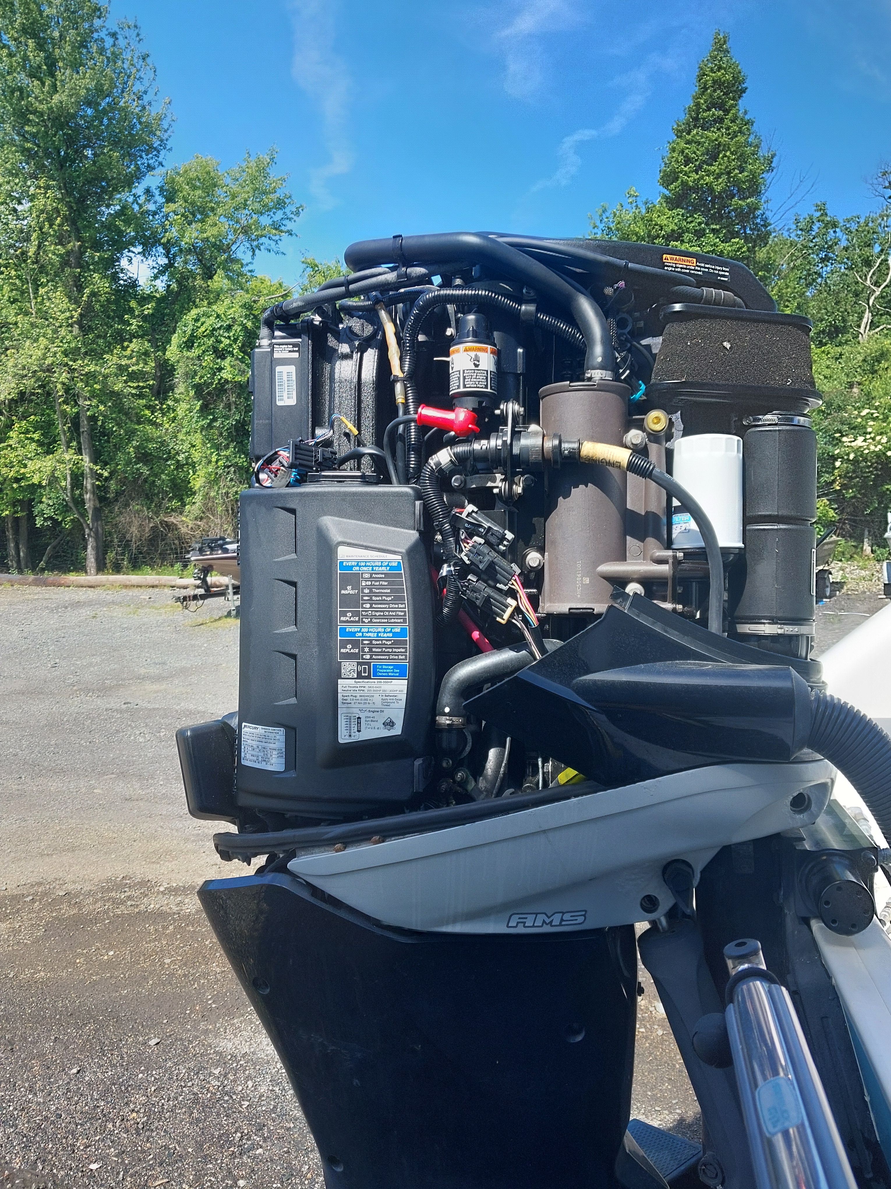 An outboard motor of a 2005 Boston Whaler 240 Outrage, parked in a lot.