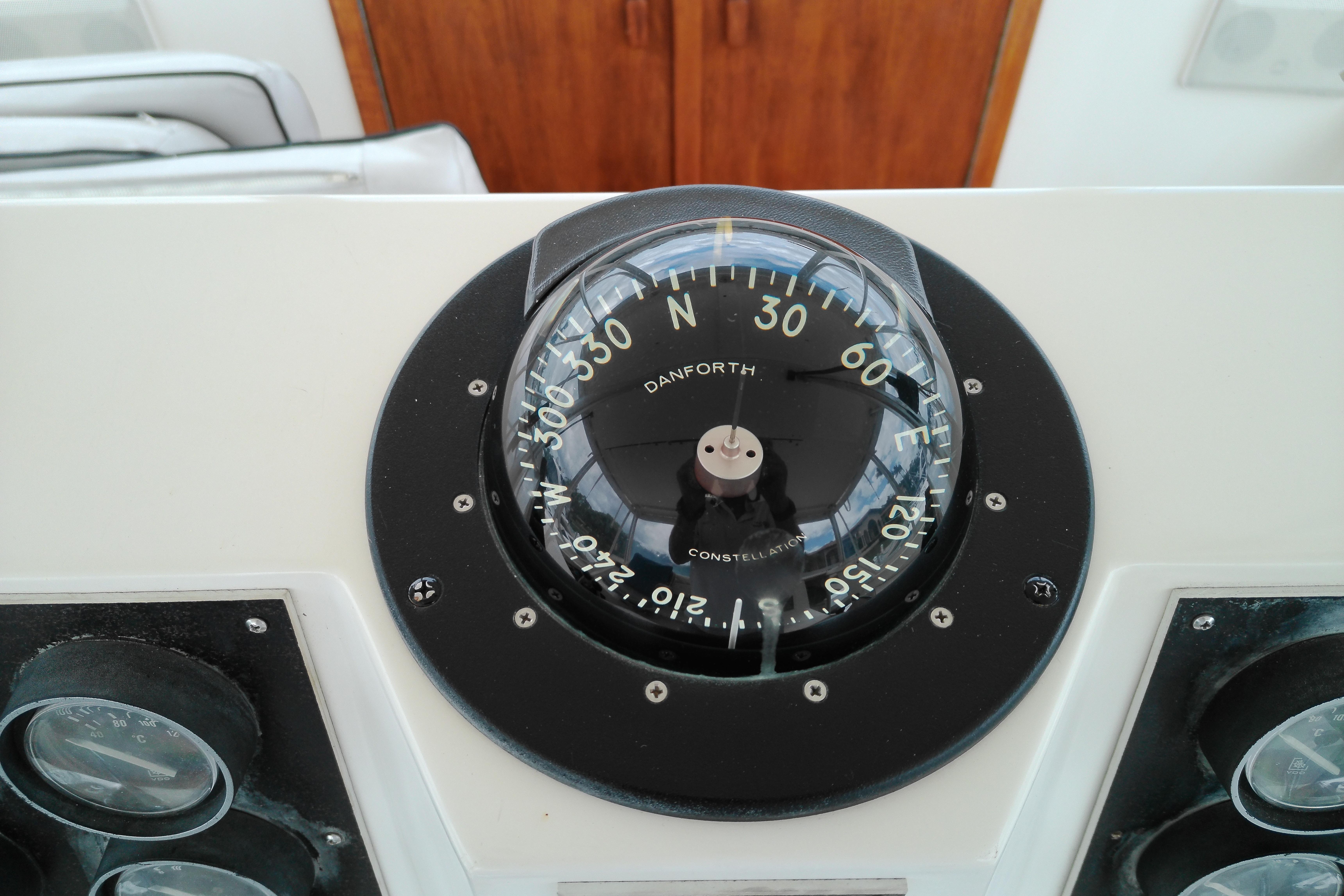 Compass on 1986 Viking 44 Motor Yacht dashboard, displaying navigation directions.