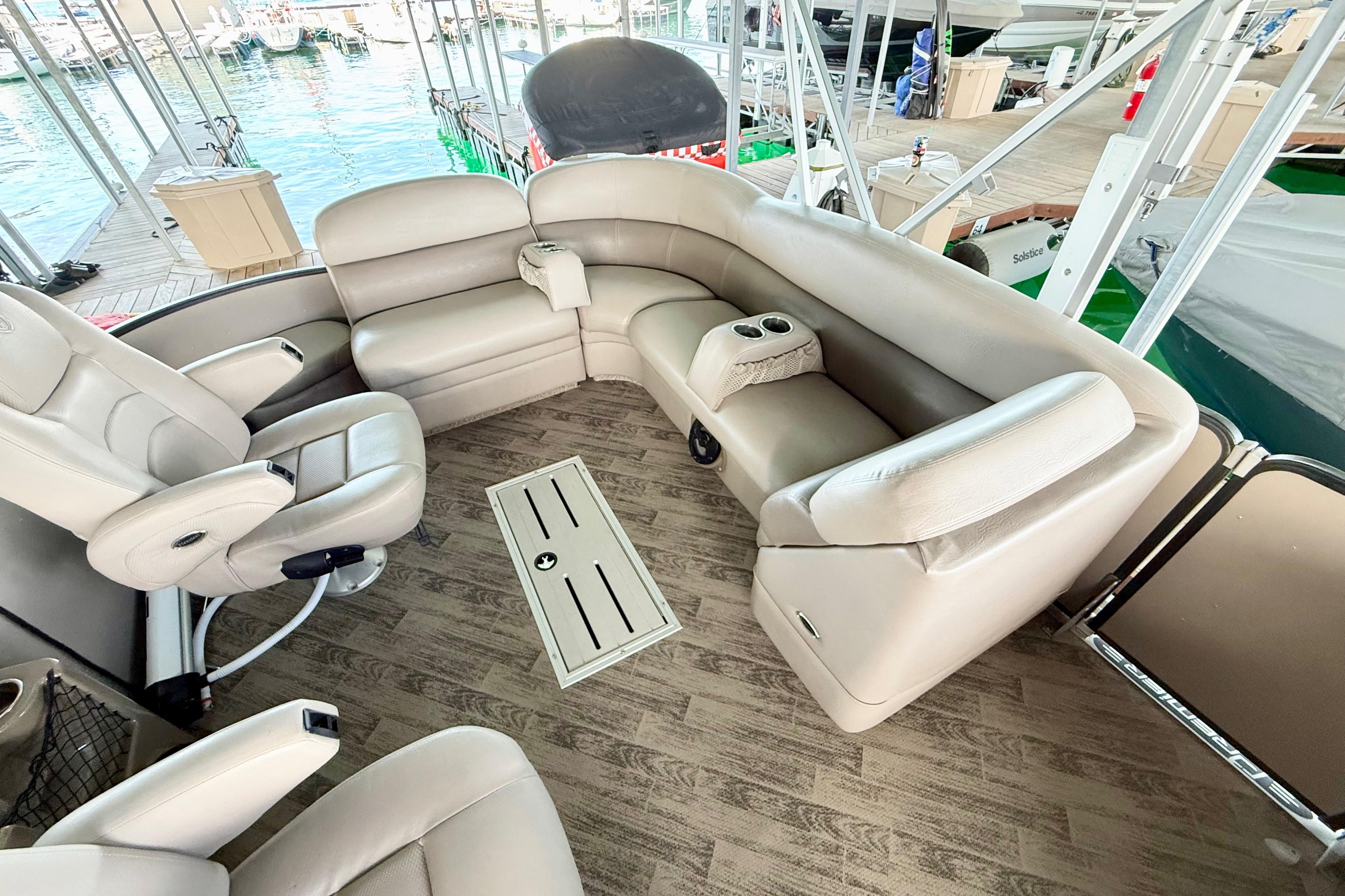 Luxurious seating on 2011 Premier 275 Grand Majestic PTX pontoon boat at marina.