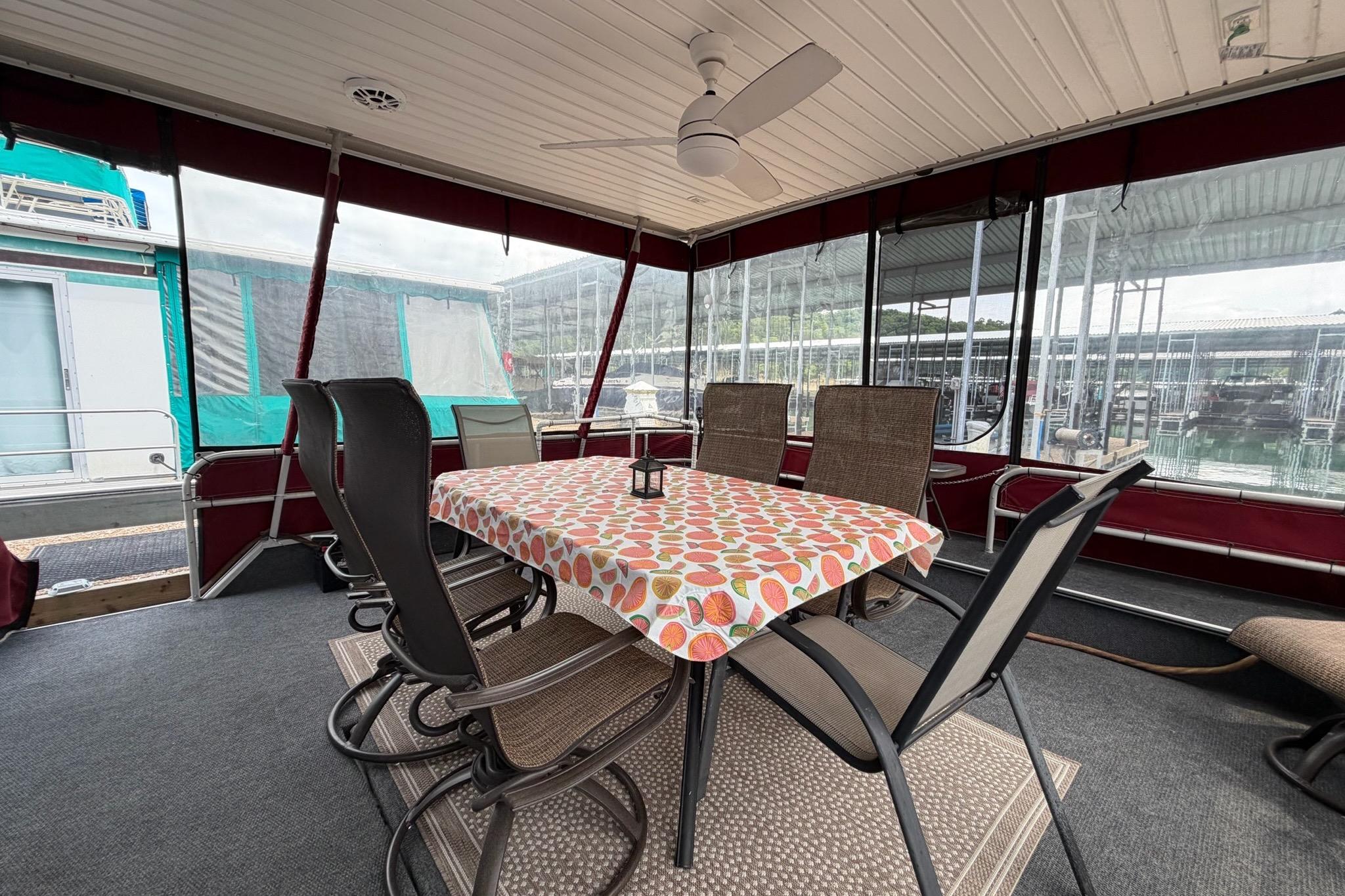 Outdoor dining area on a 1987 Sumerset 14x60 houseboat with table and chairs.